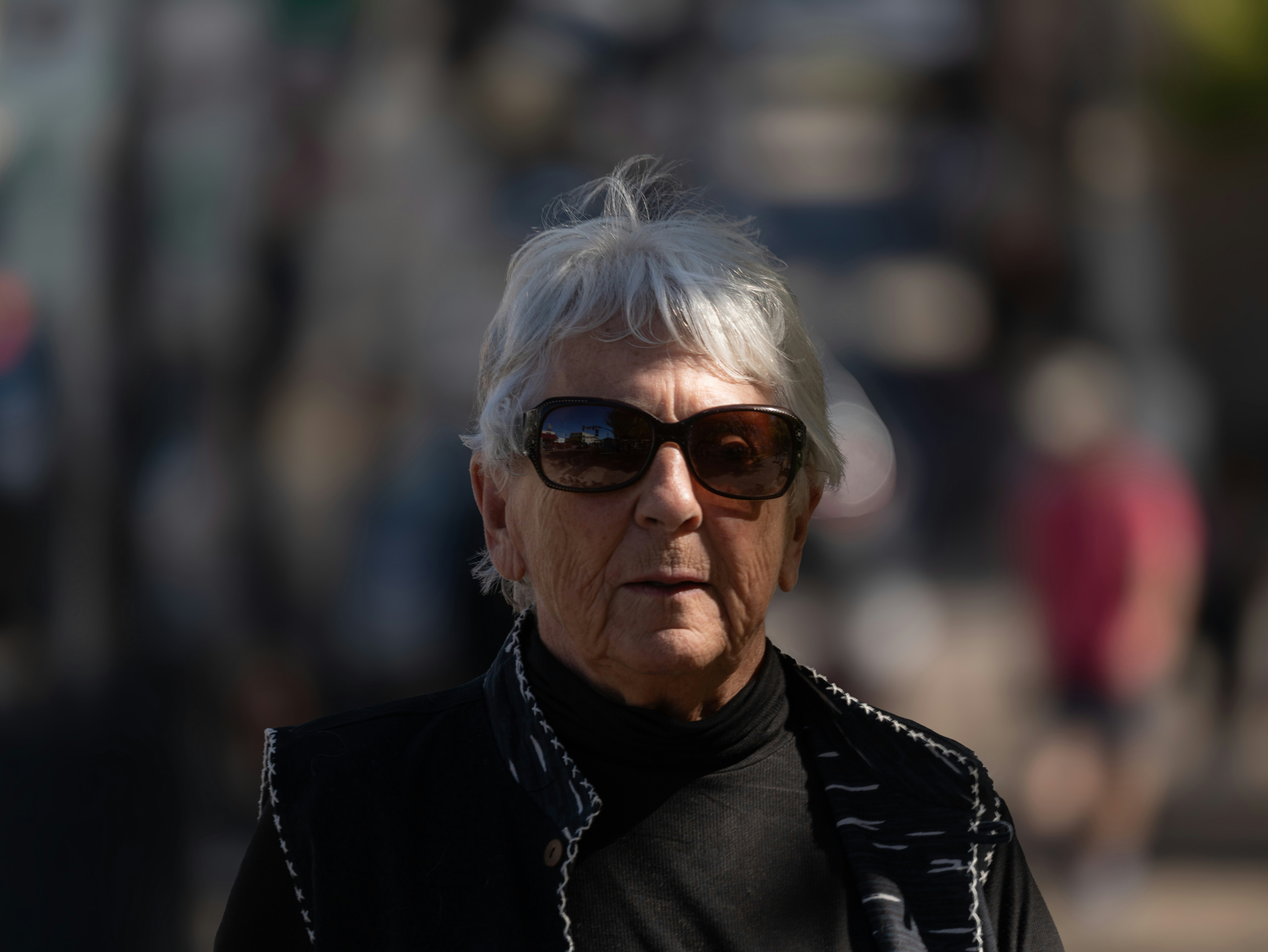 An elderly woman wearing sunglasses outdoors
