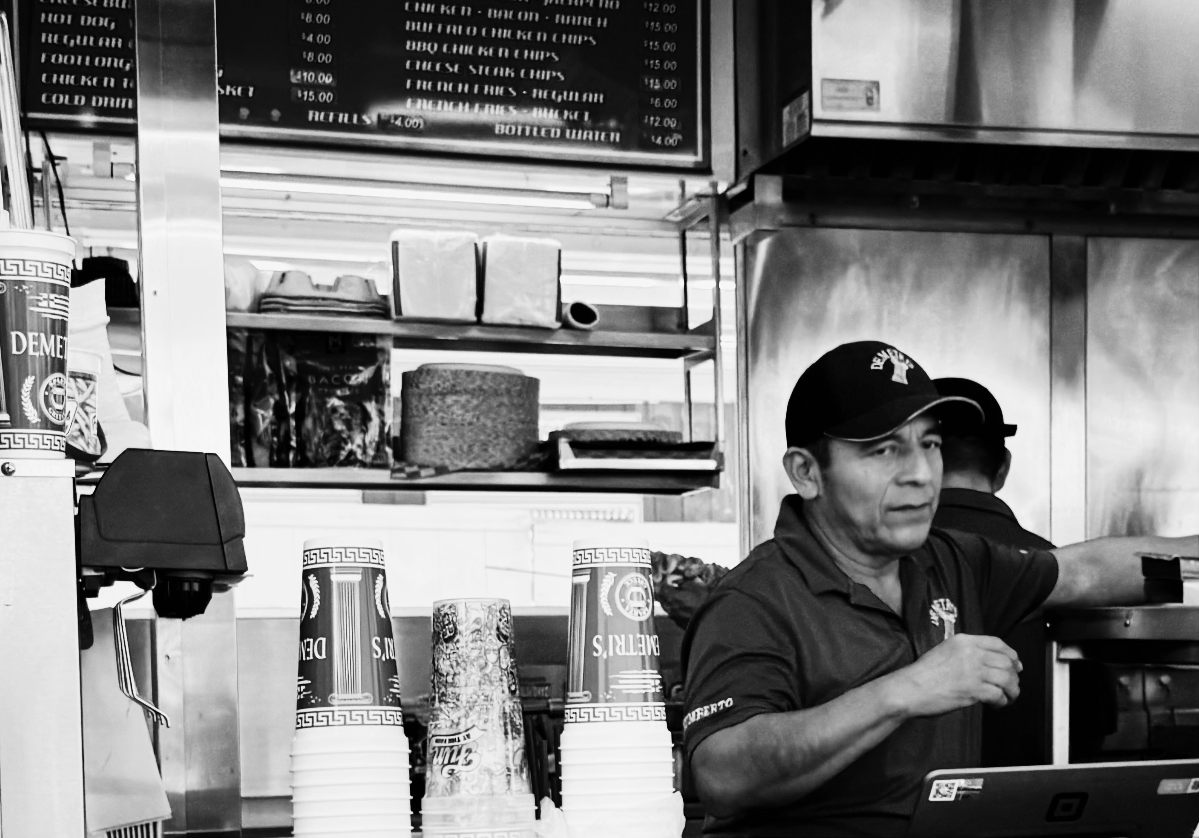 Man at a food counter, black and white
