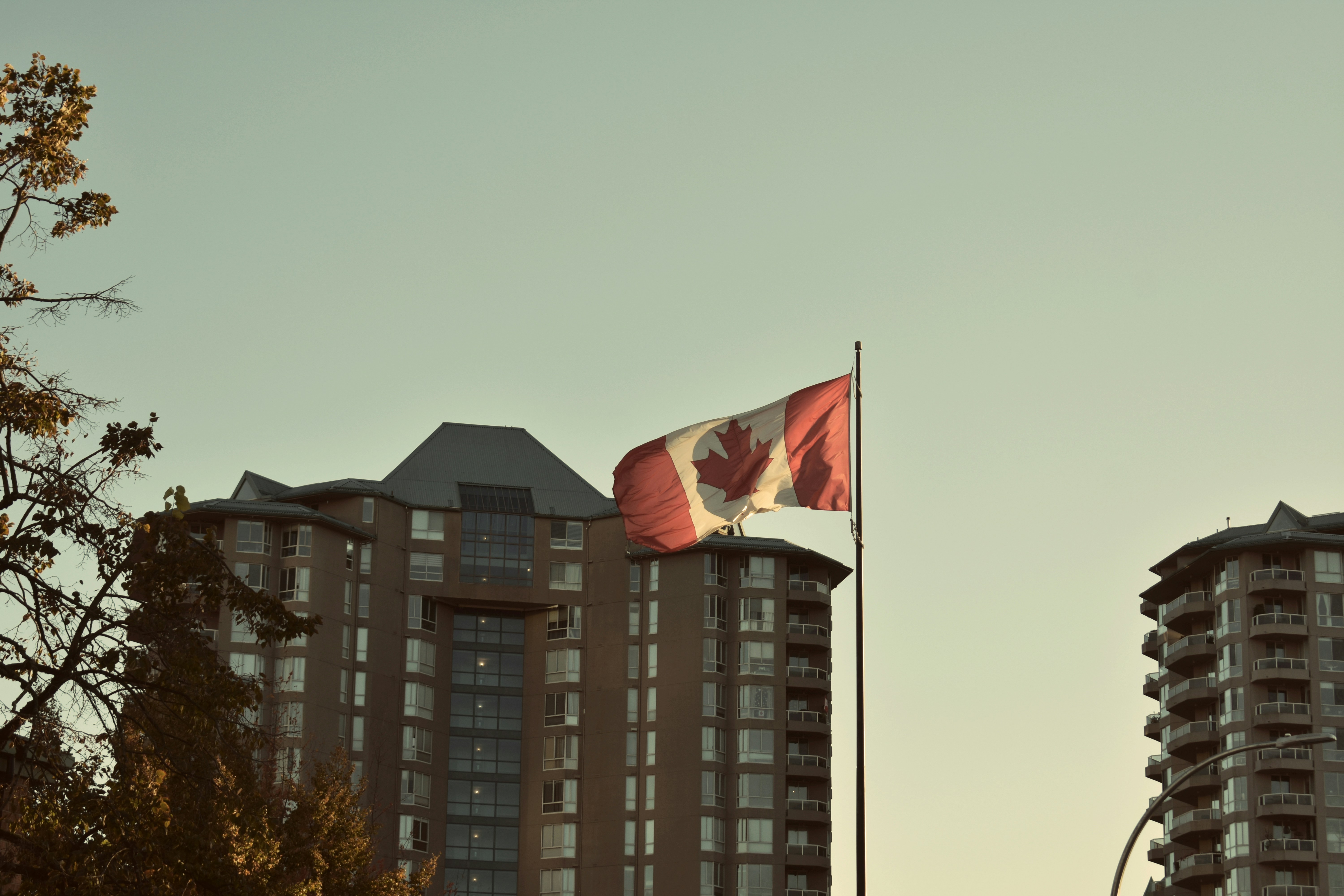 Canadian flag waving in front of apartment buildings.