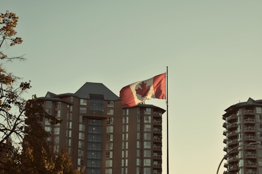 Canadian flag waving in front of apartment buildings.
