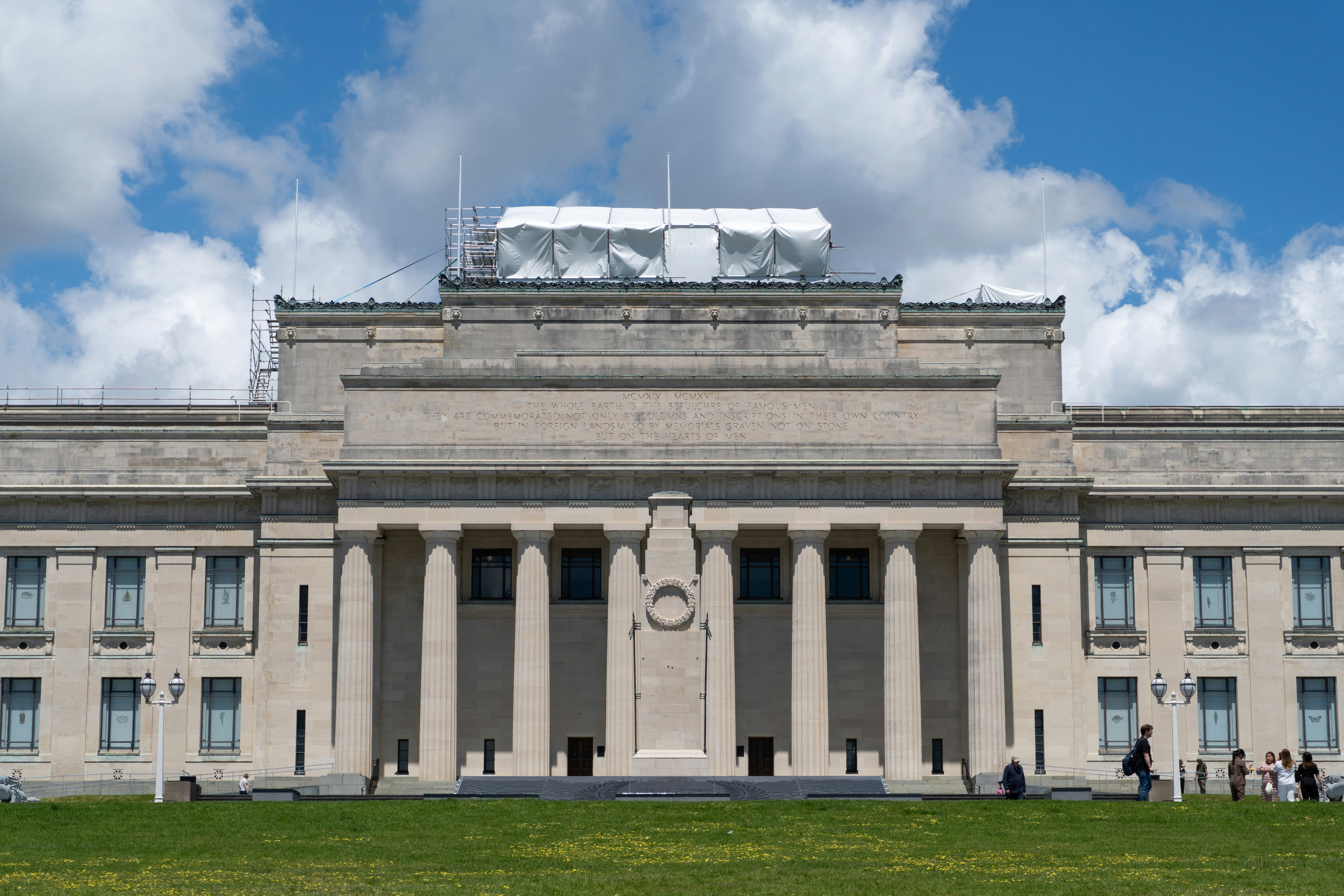 Grand stone building with classical columns and lawn