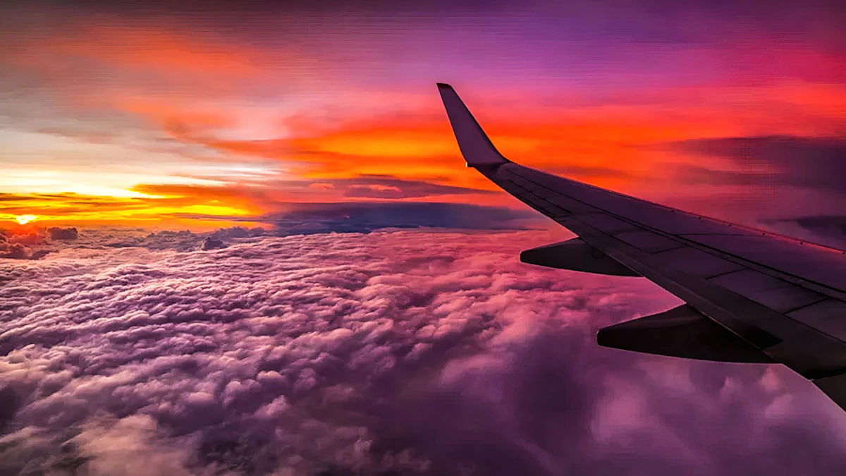 Airplane wing above the clouds at sunset