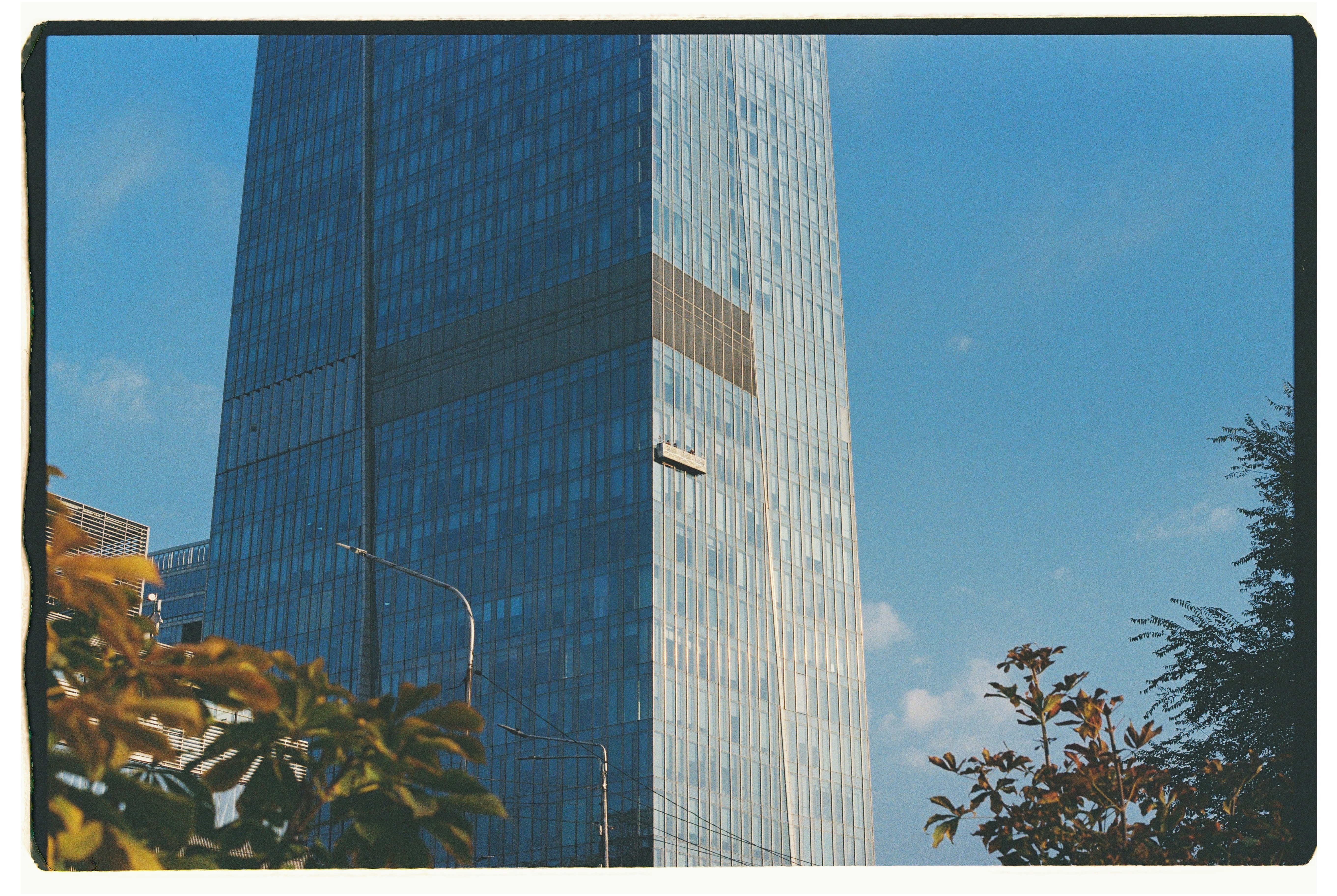 Modern glass skyscraper against a clear blue sky.