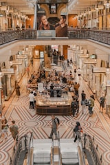 People shopping and dining in a grand indoor arcade.