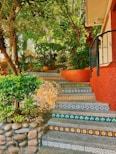 Colorful tiled stairs ascend a lush, tropical hillside.
