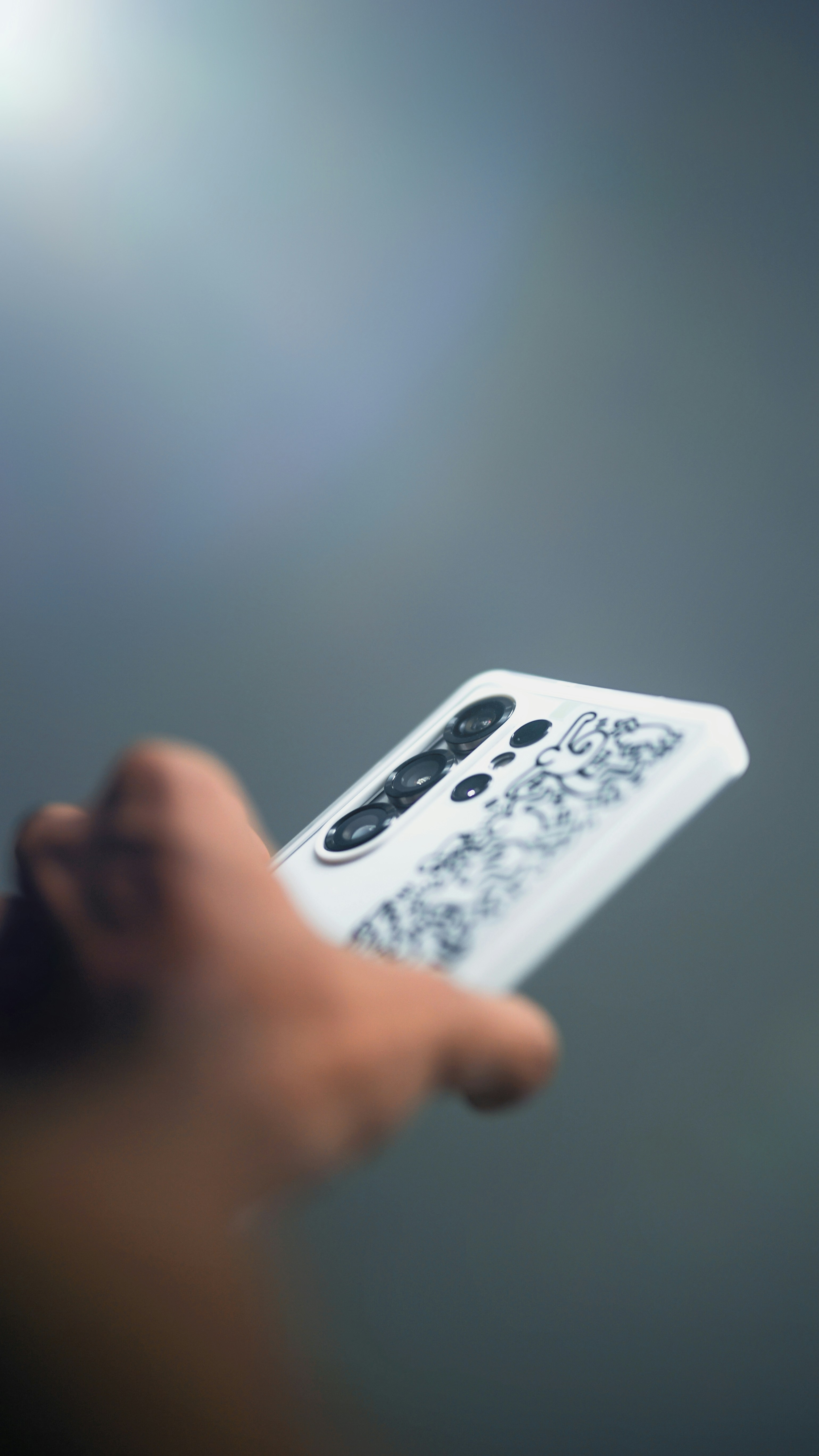 Mano sosteniendo un teléfono inteligente con una funda estampada