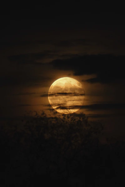 Luna llena entre nubes oscuras, ambiente místico