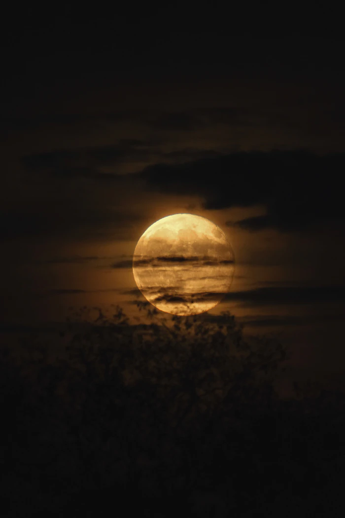 Luna llena entre nubes oscuras representando a Hécate