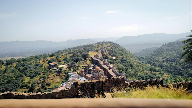 The Kumbhalgarh fort wall winding through green Aravalli hills