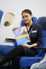 Young woman in uniform holding aviation prospectus