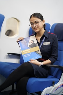 Young woman in uniform holding aviation prospectus