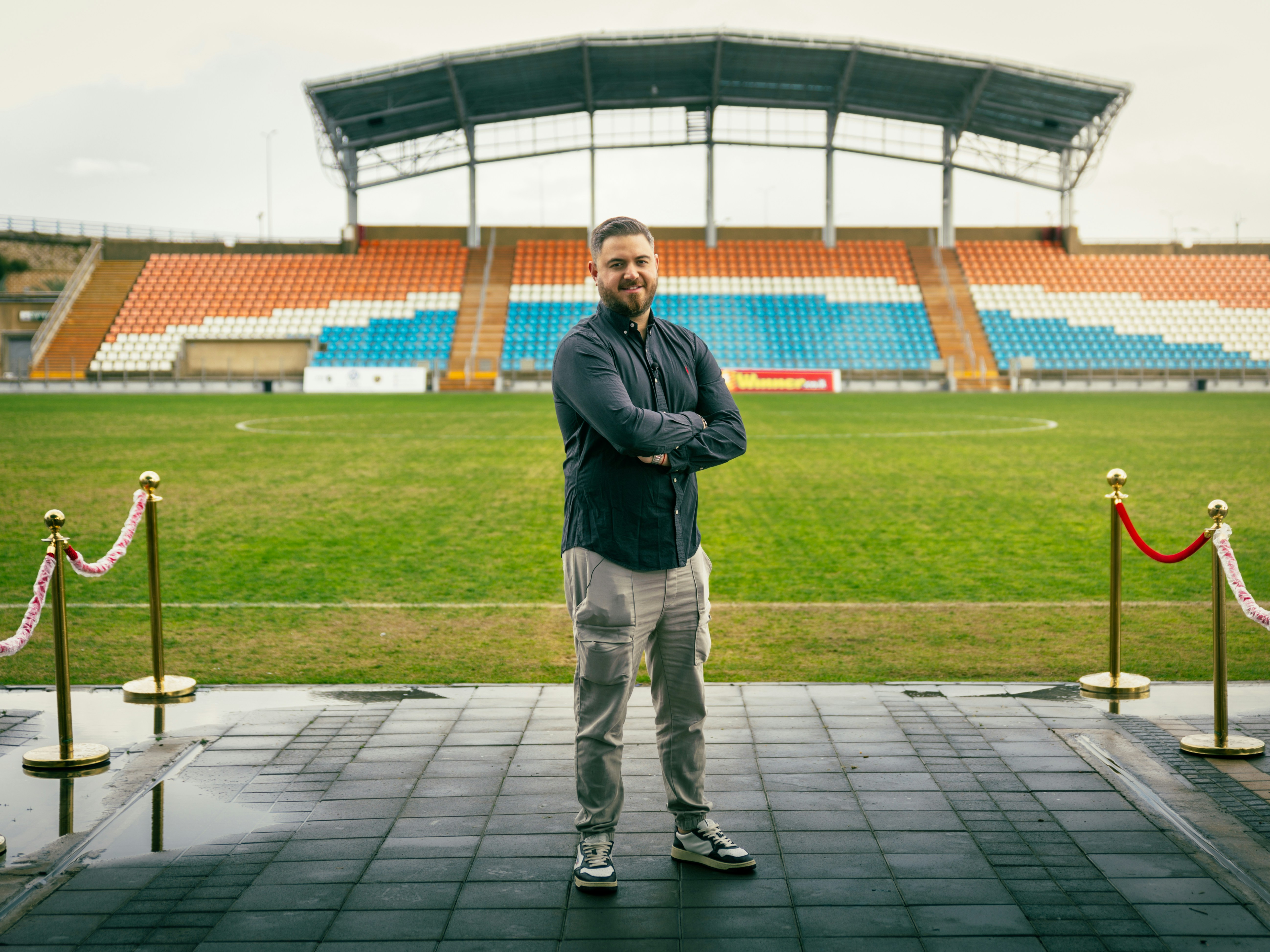 Man standing on red carpet at stadium