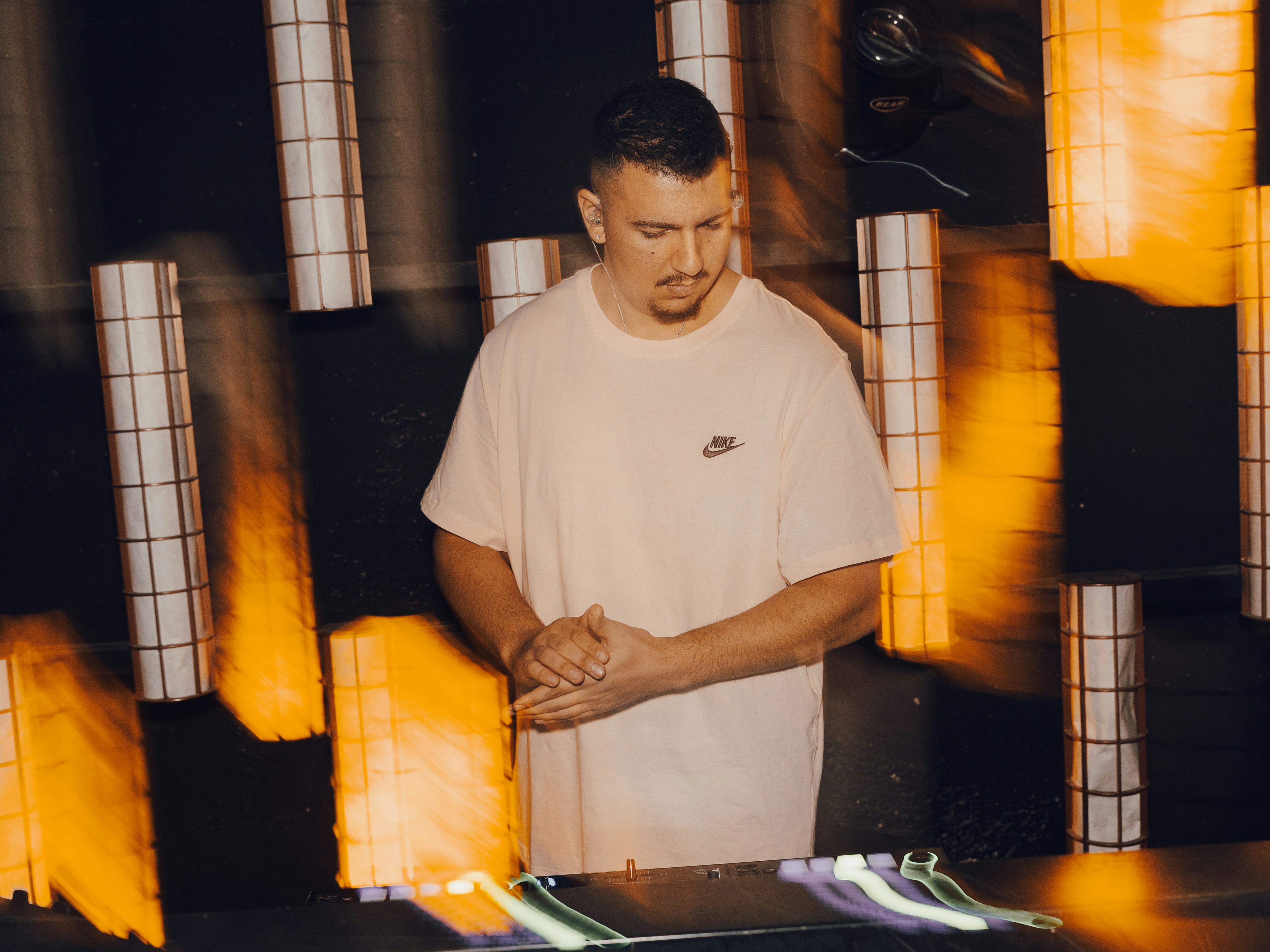 Uomo in piedi con le mani giunte, luci sfocate