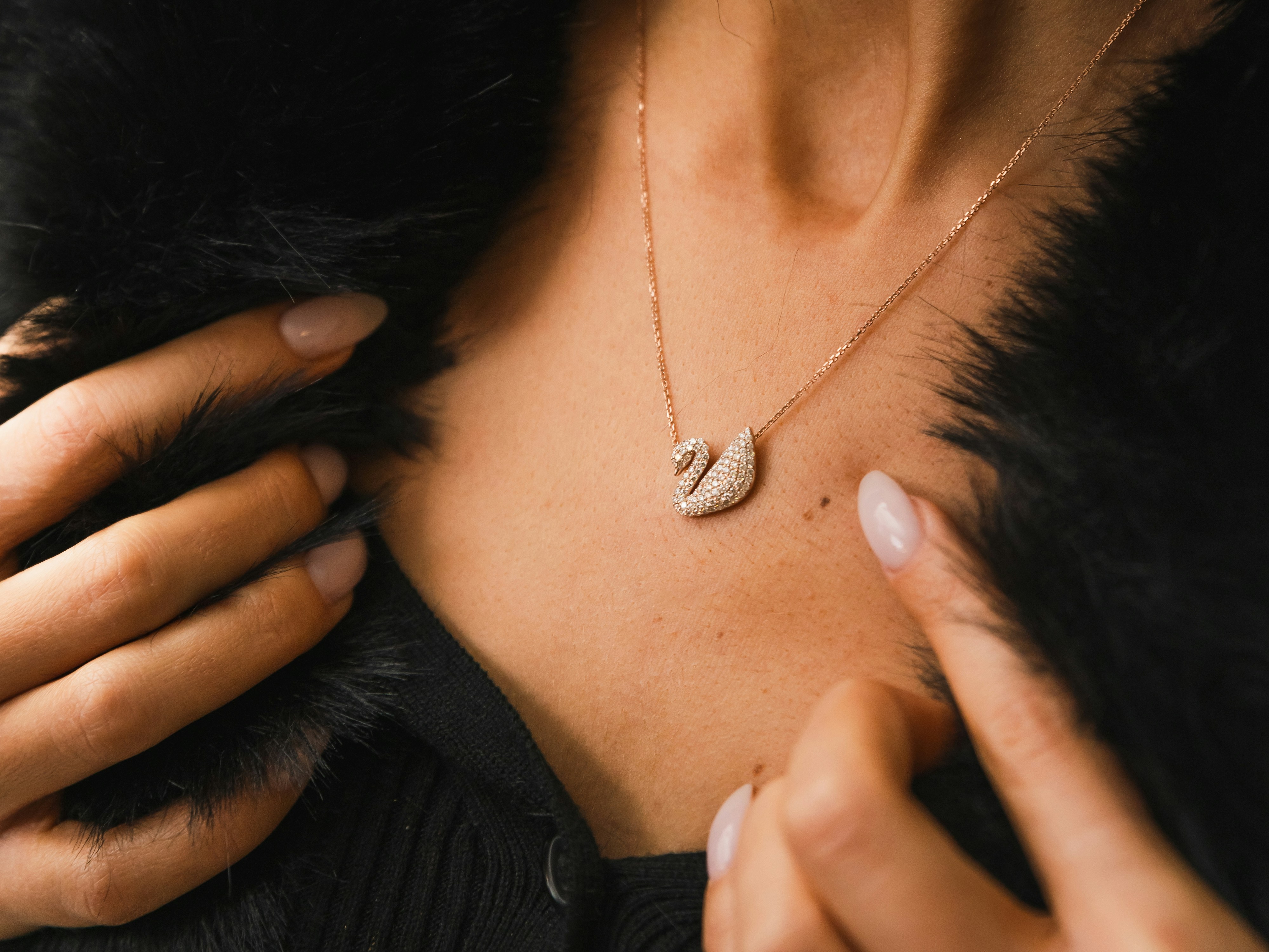 Woman wearing a swan pendant necklace