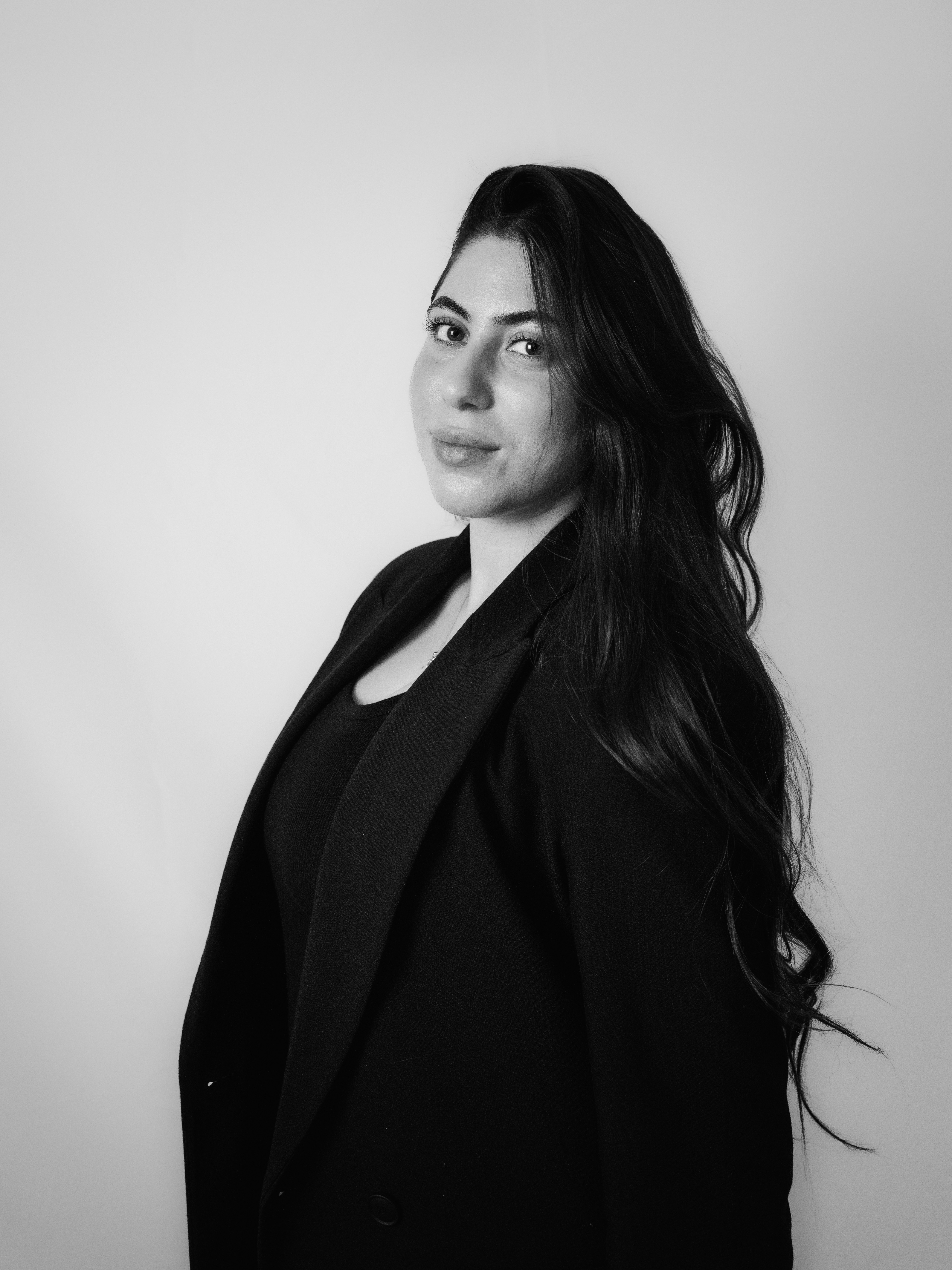 A woman in a black blazer and top.