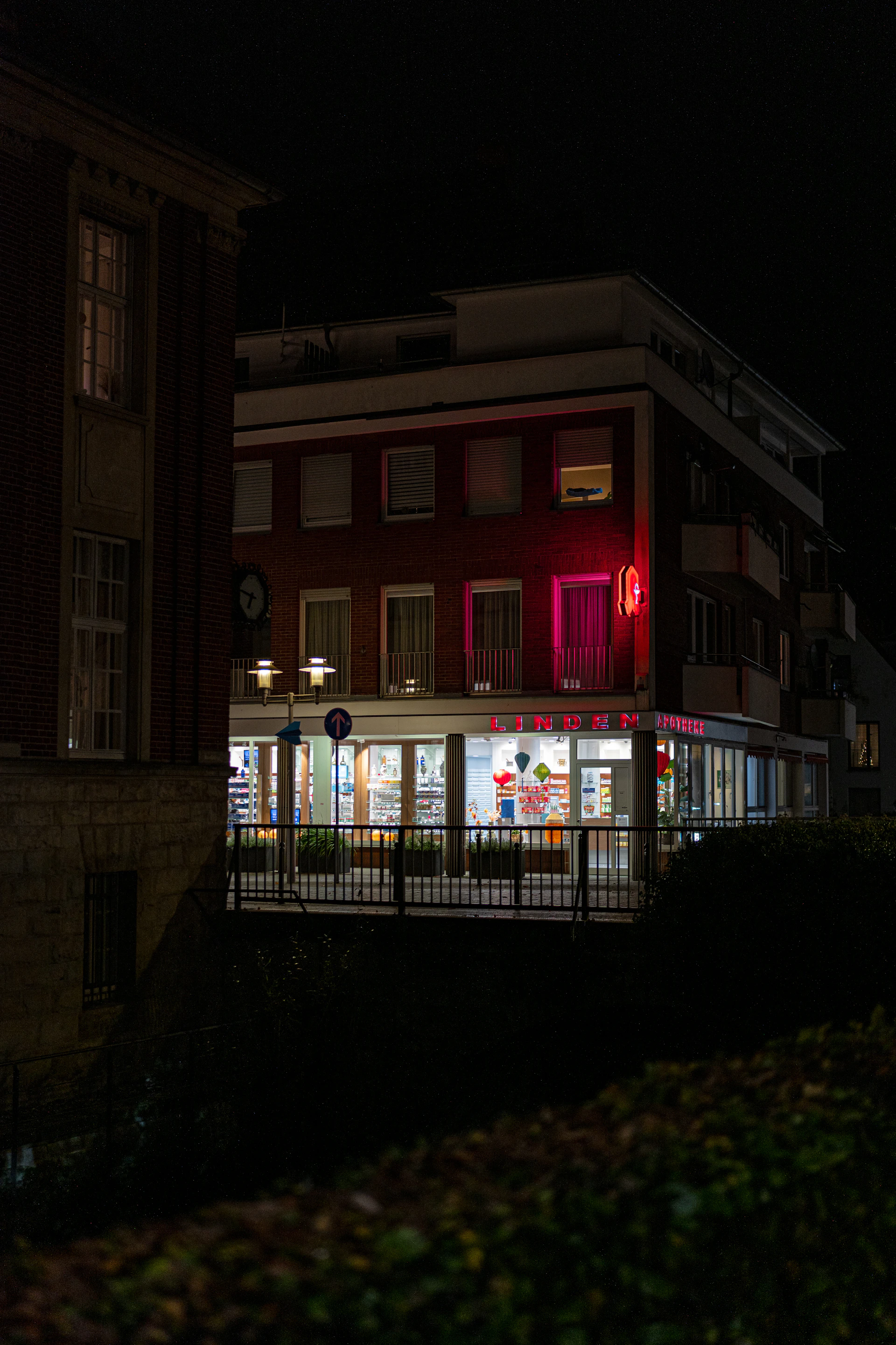 Building illuminated at night with red neon sign.