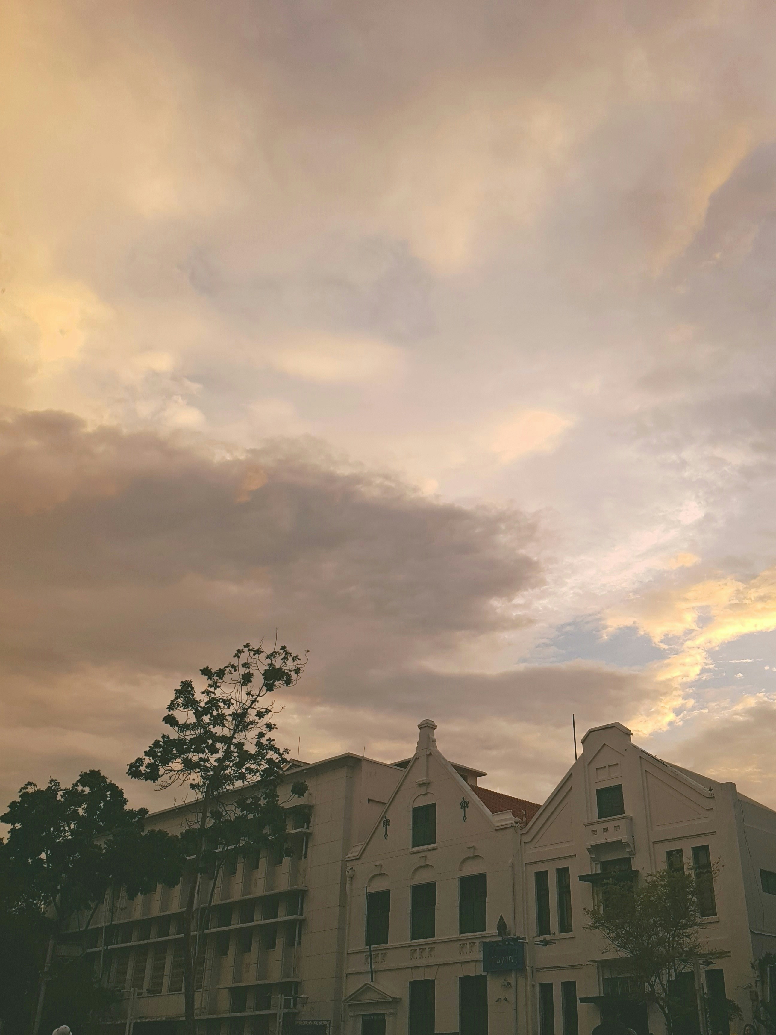 Historische Gebäude vor einem wolkenverhangenen Sonnenuntergangshimmel