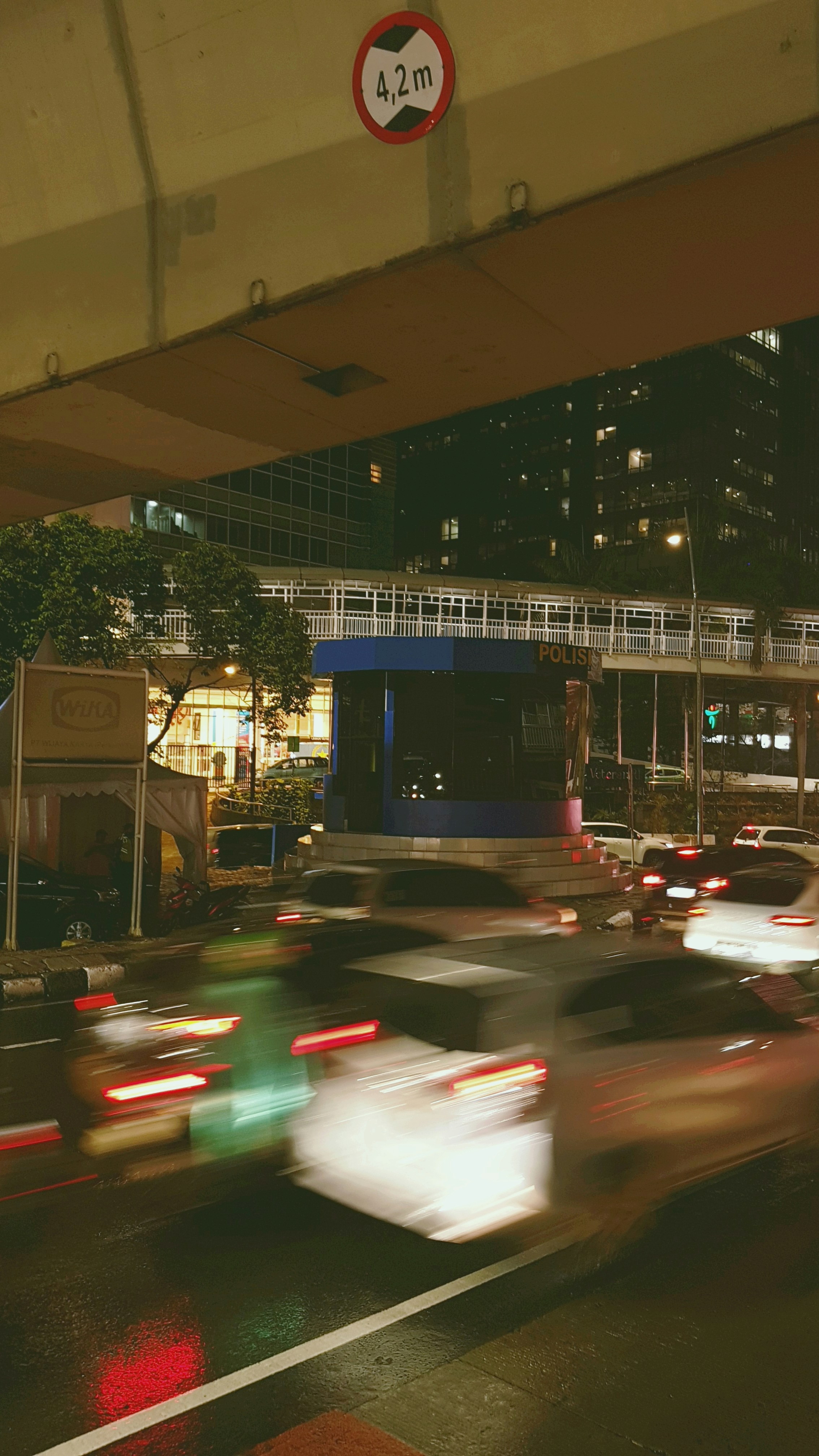 Der Verkehr fließt nachts unter einer Brücke hindurch