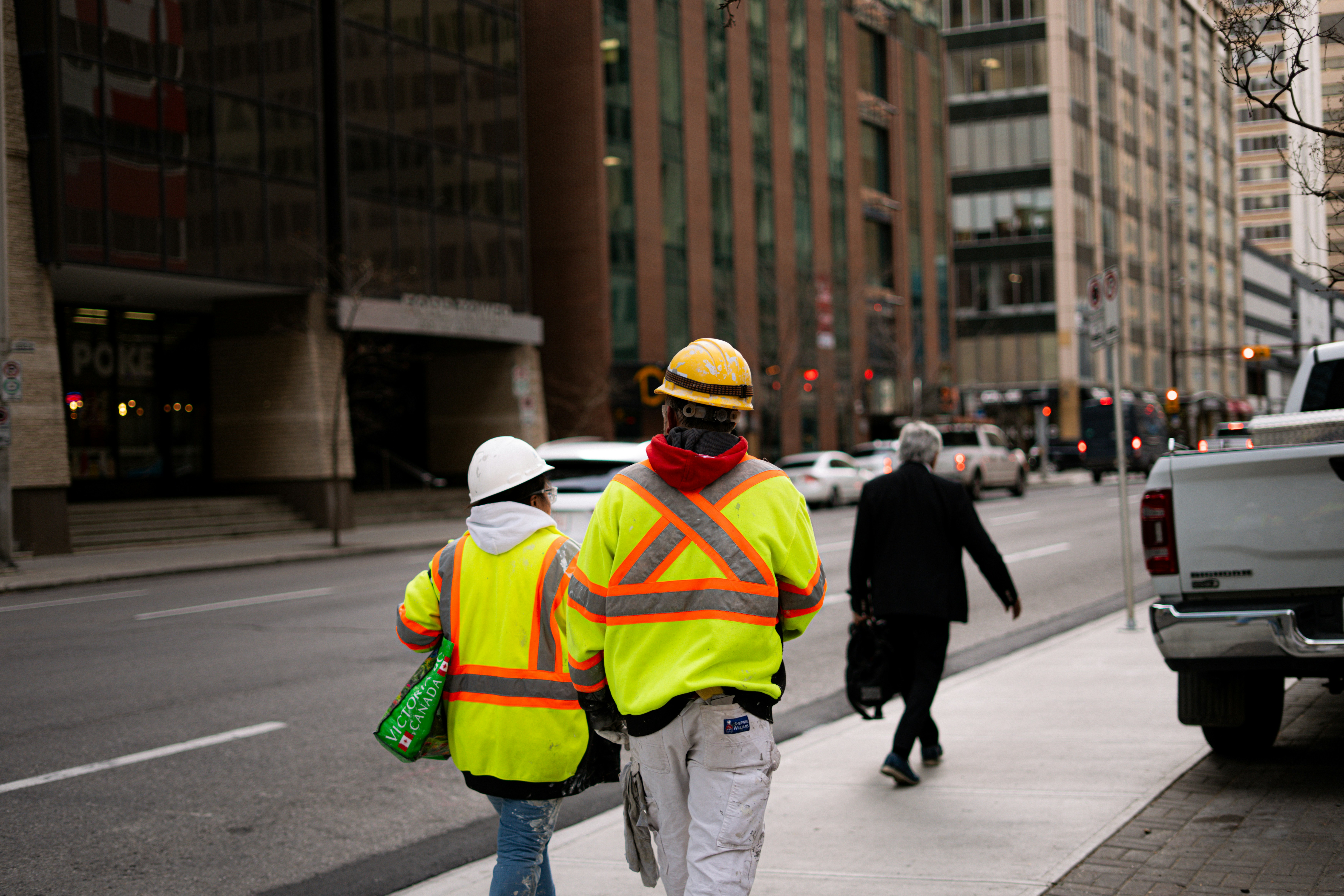 Two construction workers on sidewalk