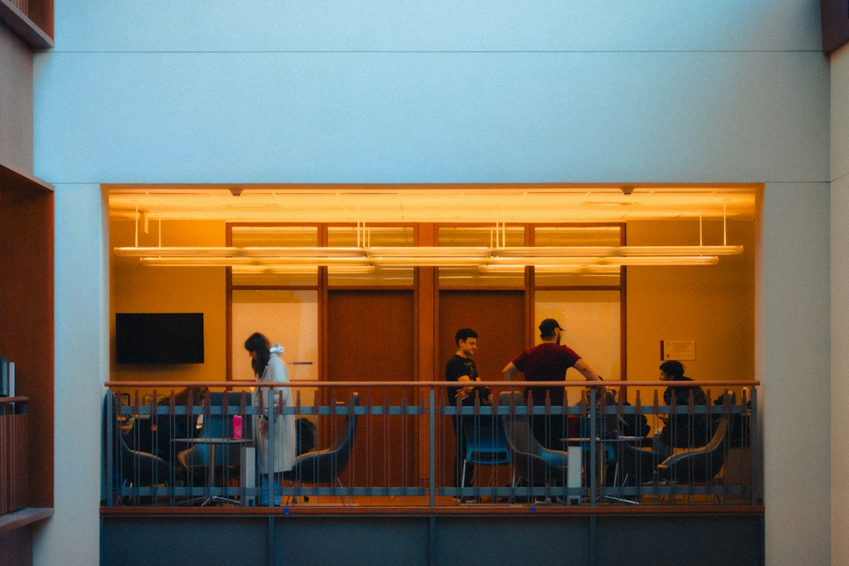 A diverse group of people chatting on a balcony, engaging in icebreaker questions for groups and team building activities.