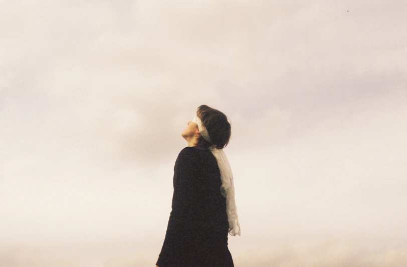 Woman looking up at cloudy sky