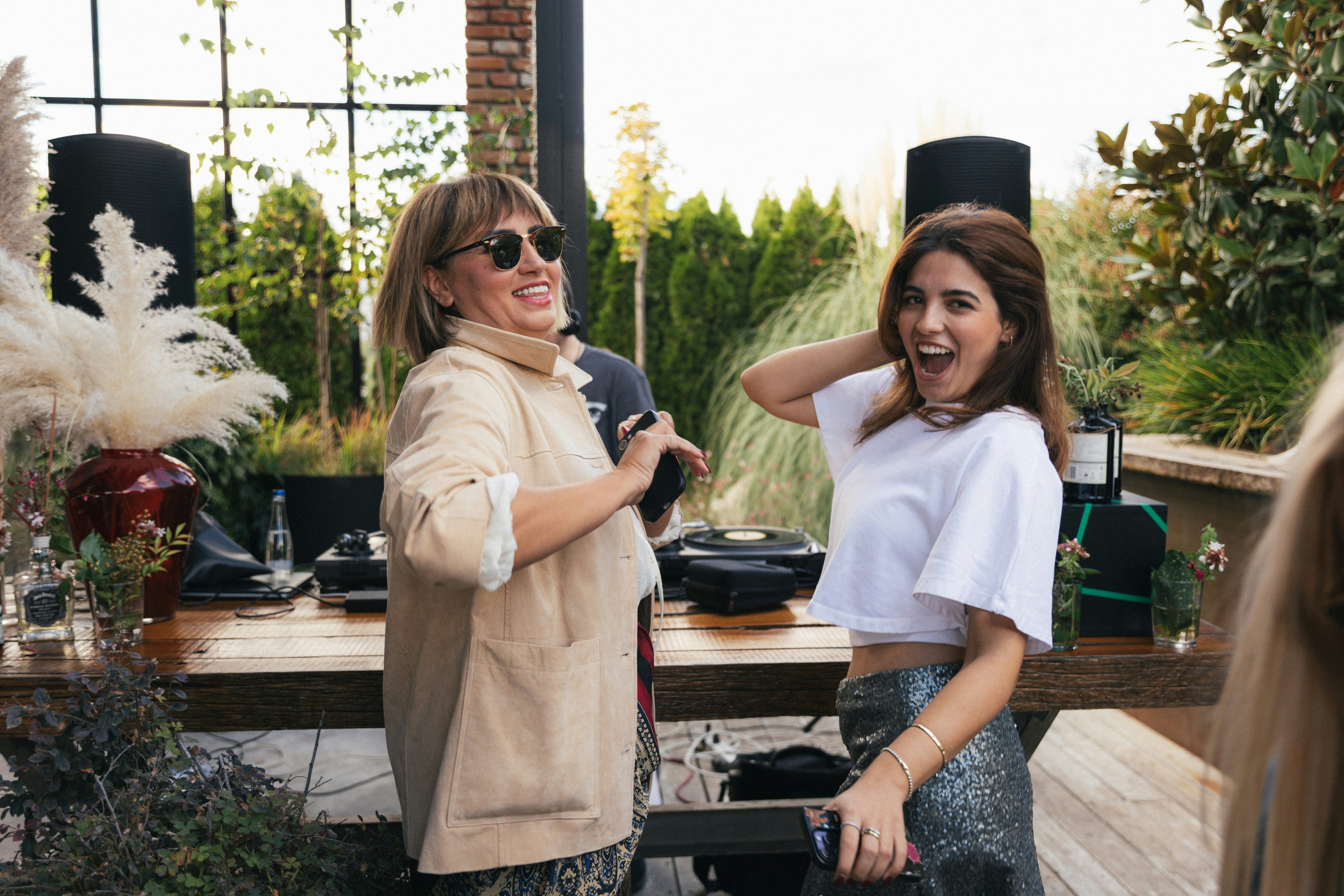 Two women laughing and dancing outdoors
