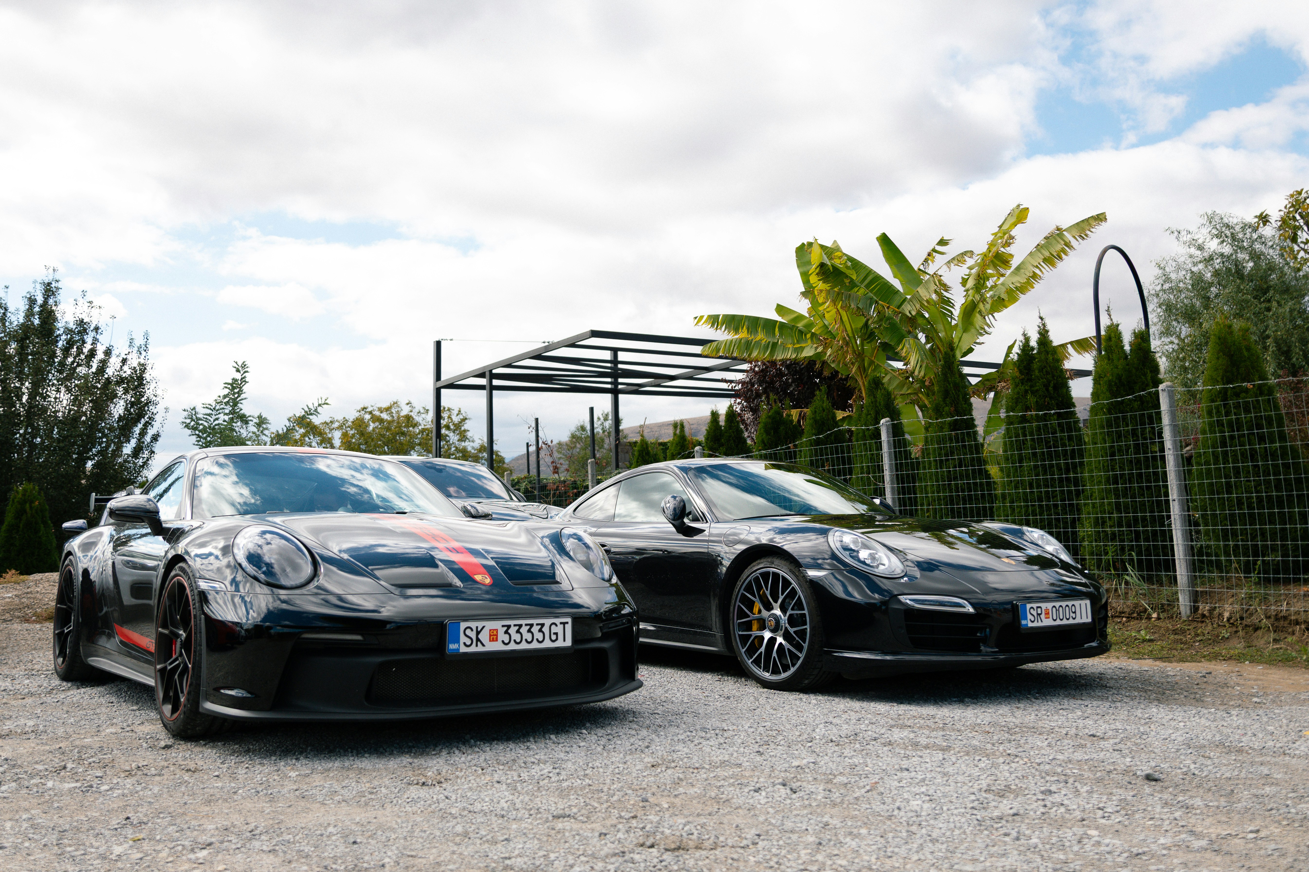 Two black porsche cars parked outdoors
