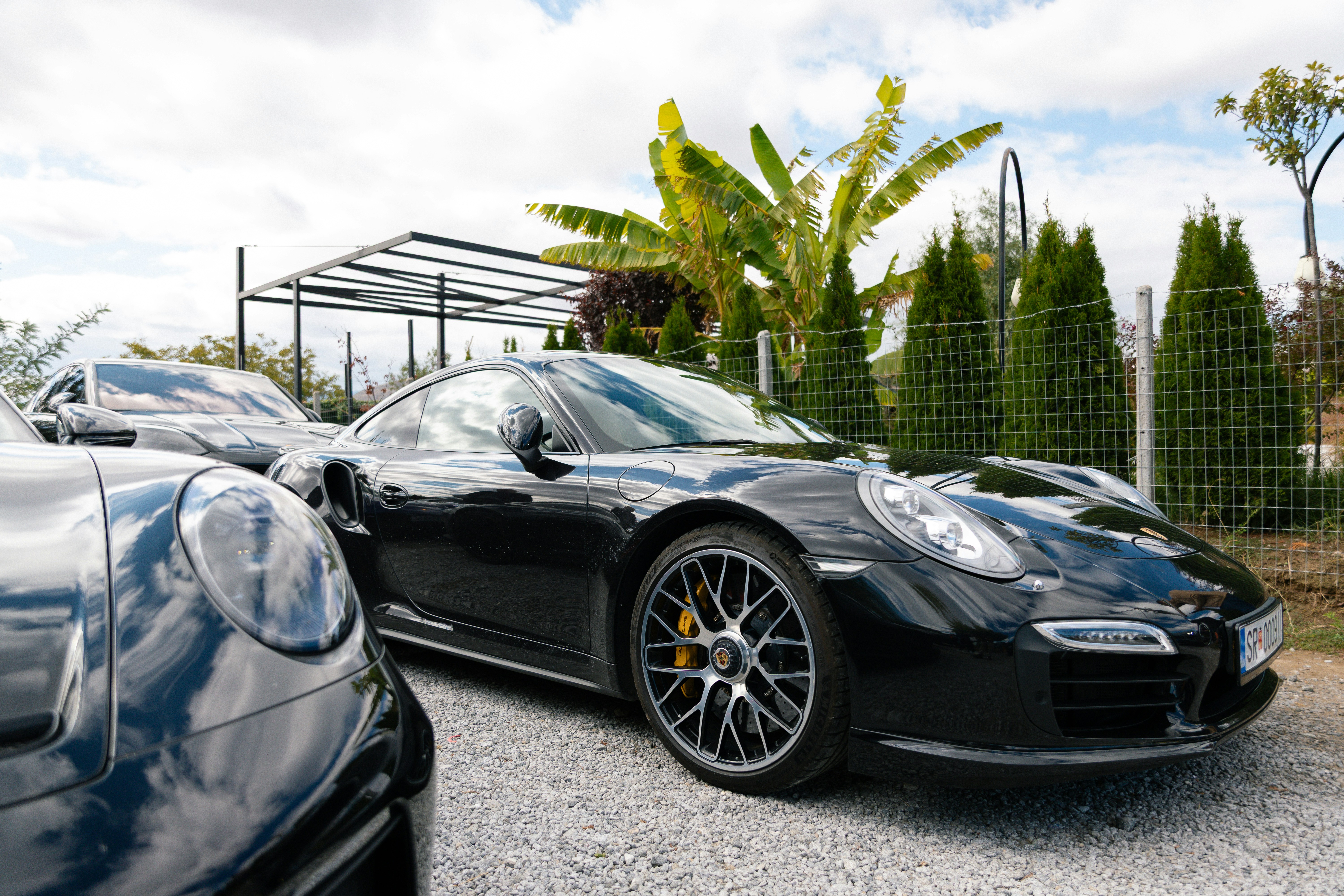 Several black luxury sports cars parked outdoors.