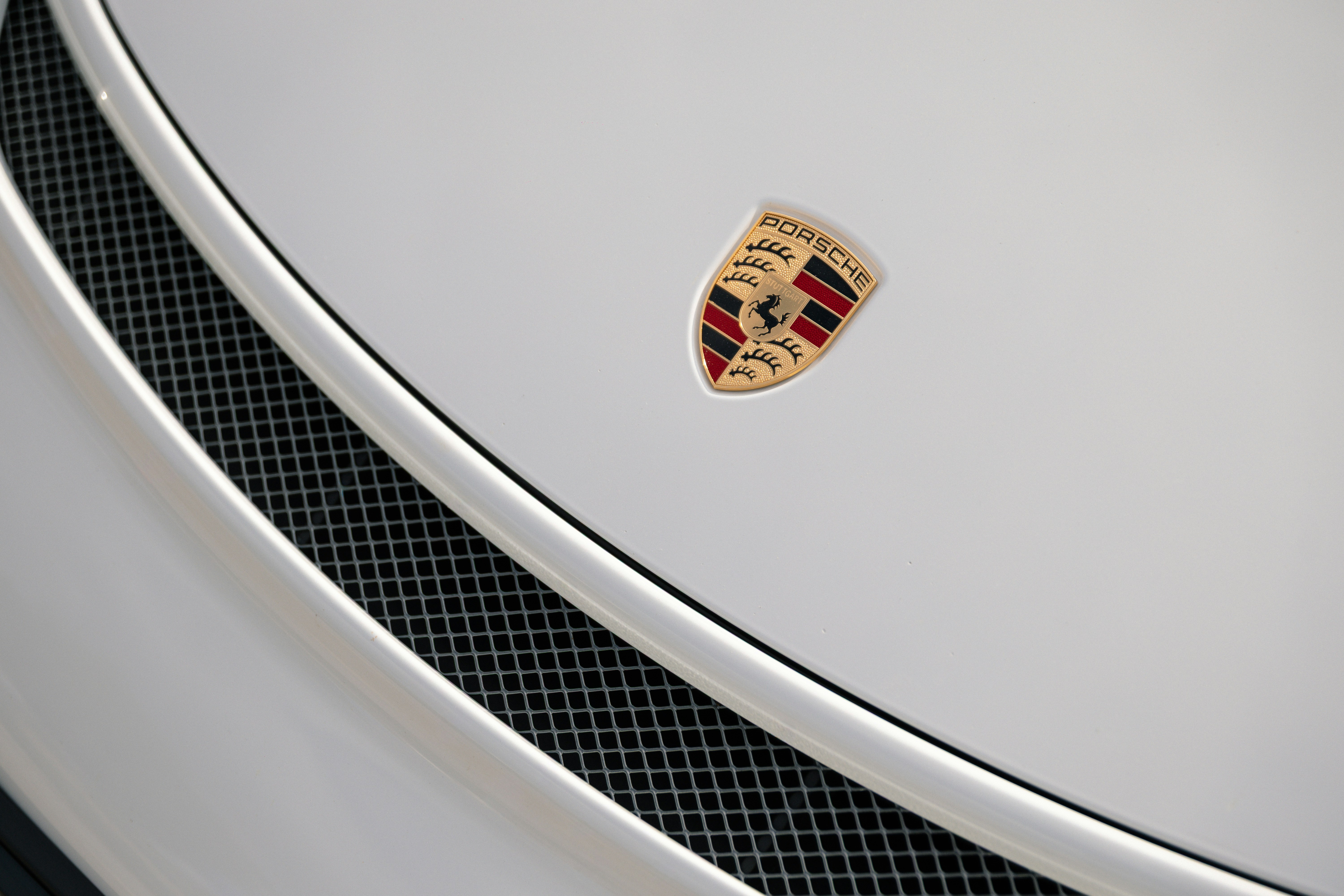 Porsche emblem on a white car hood