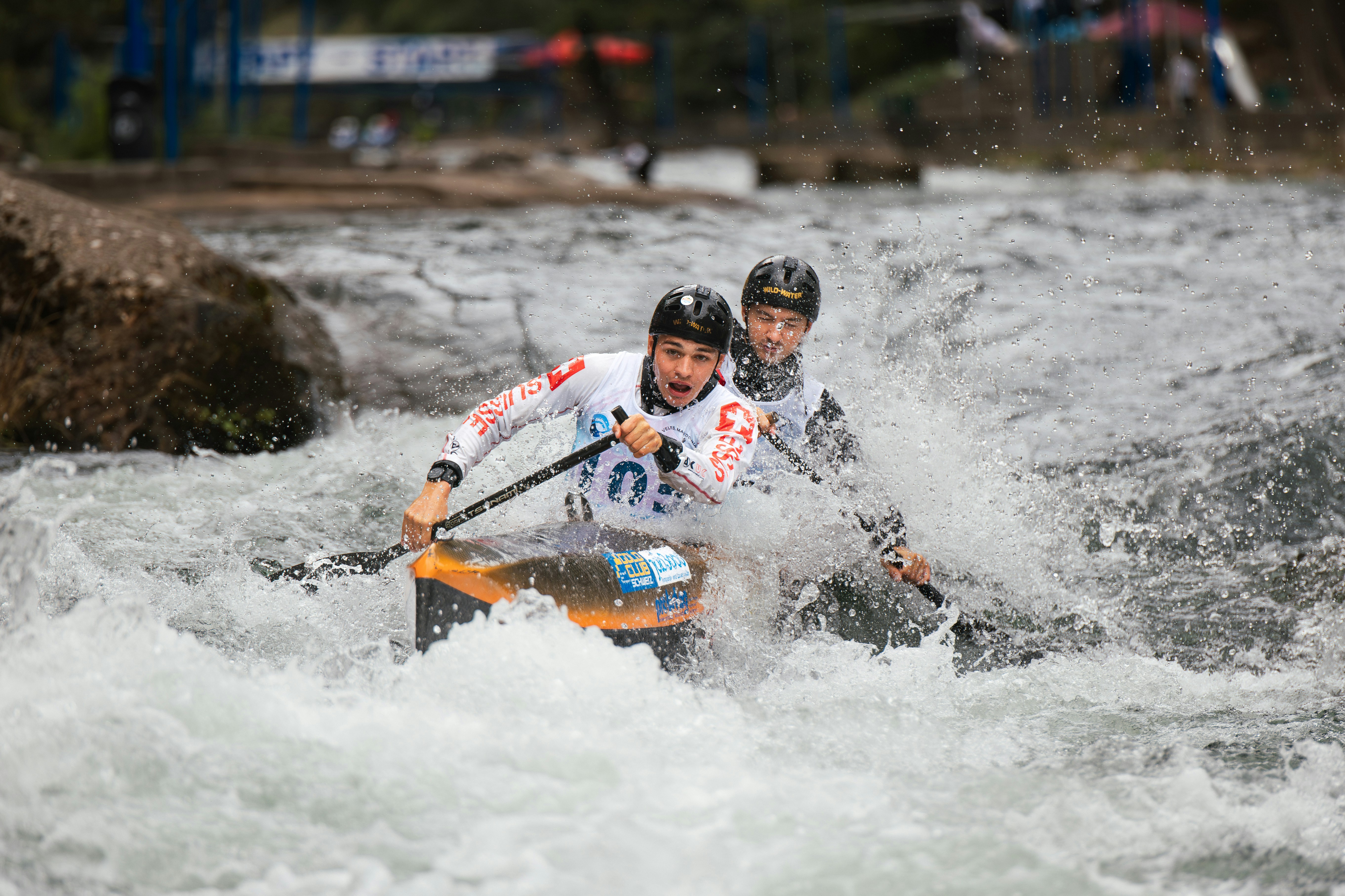 Two men in a canoe navigating whitewater rapids.