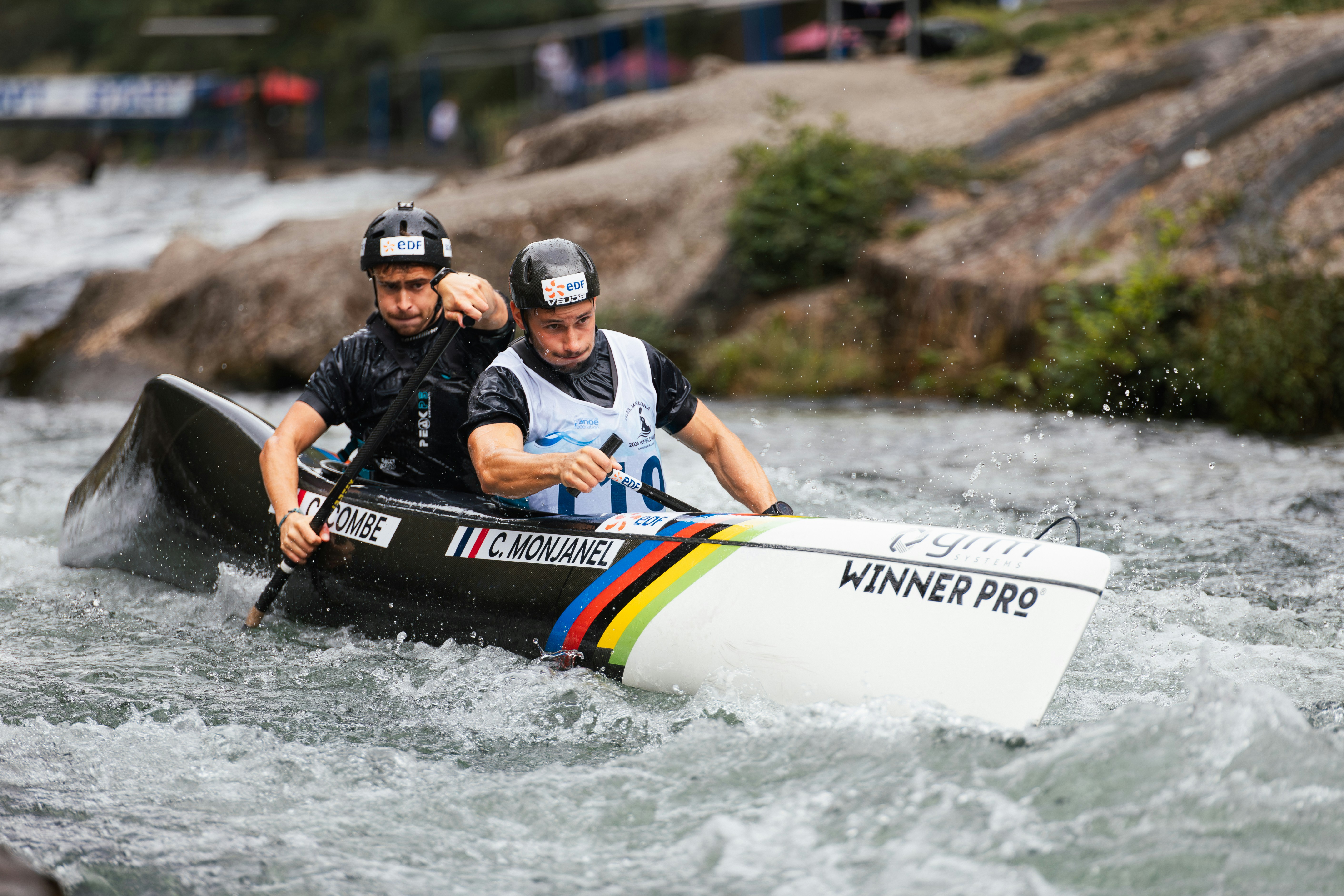 Two men in a canoe navigating rapids
