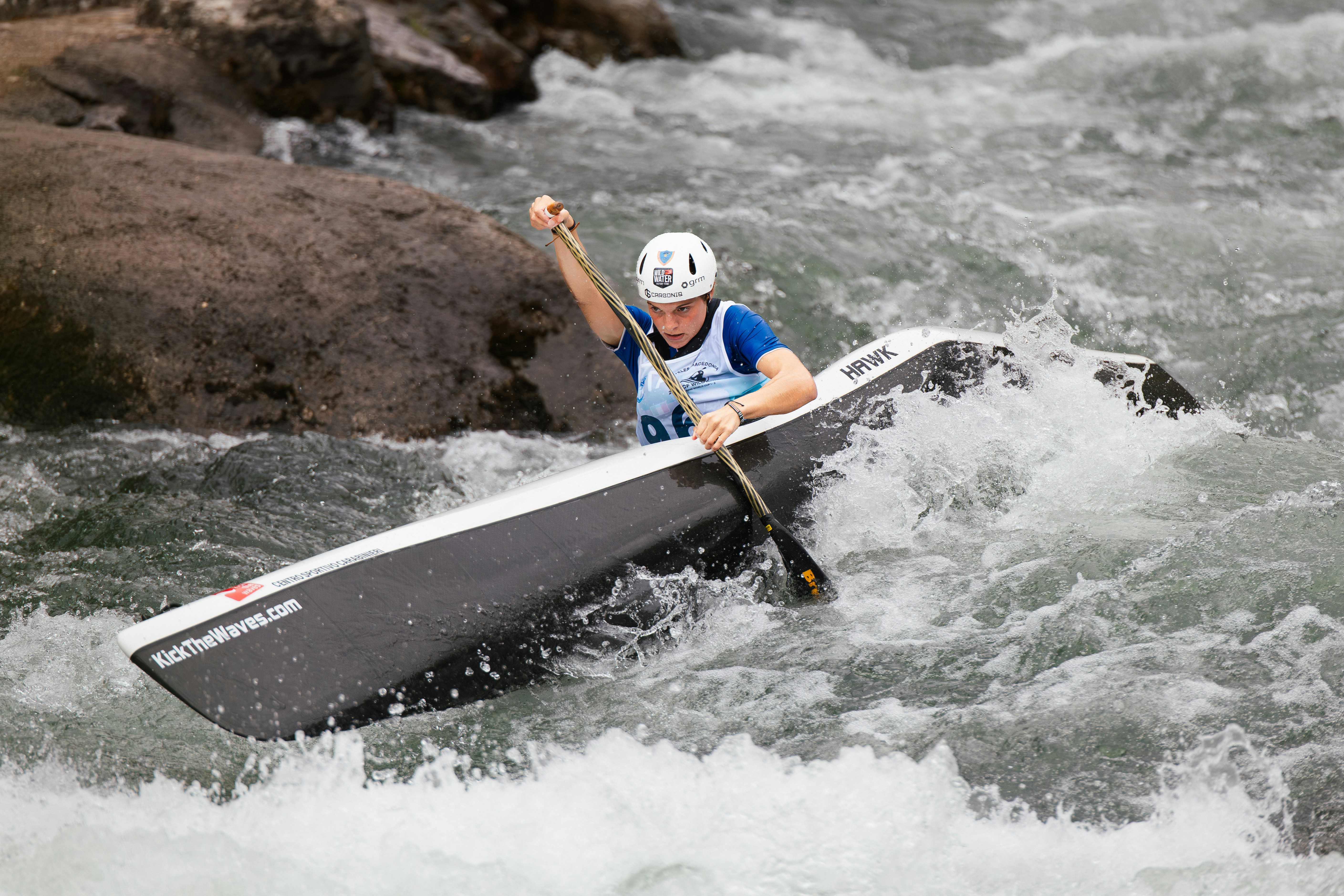 A person kayaks down a rocky river.