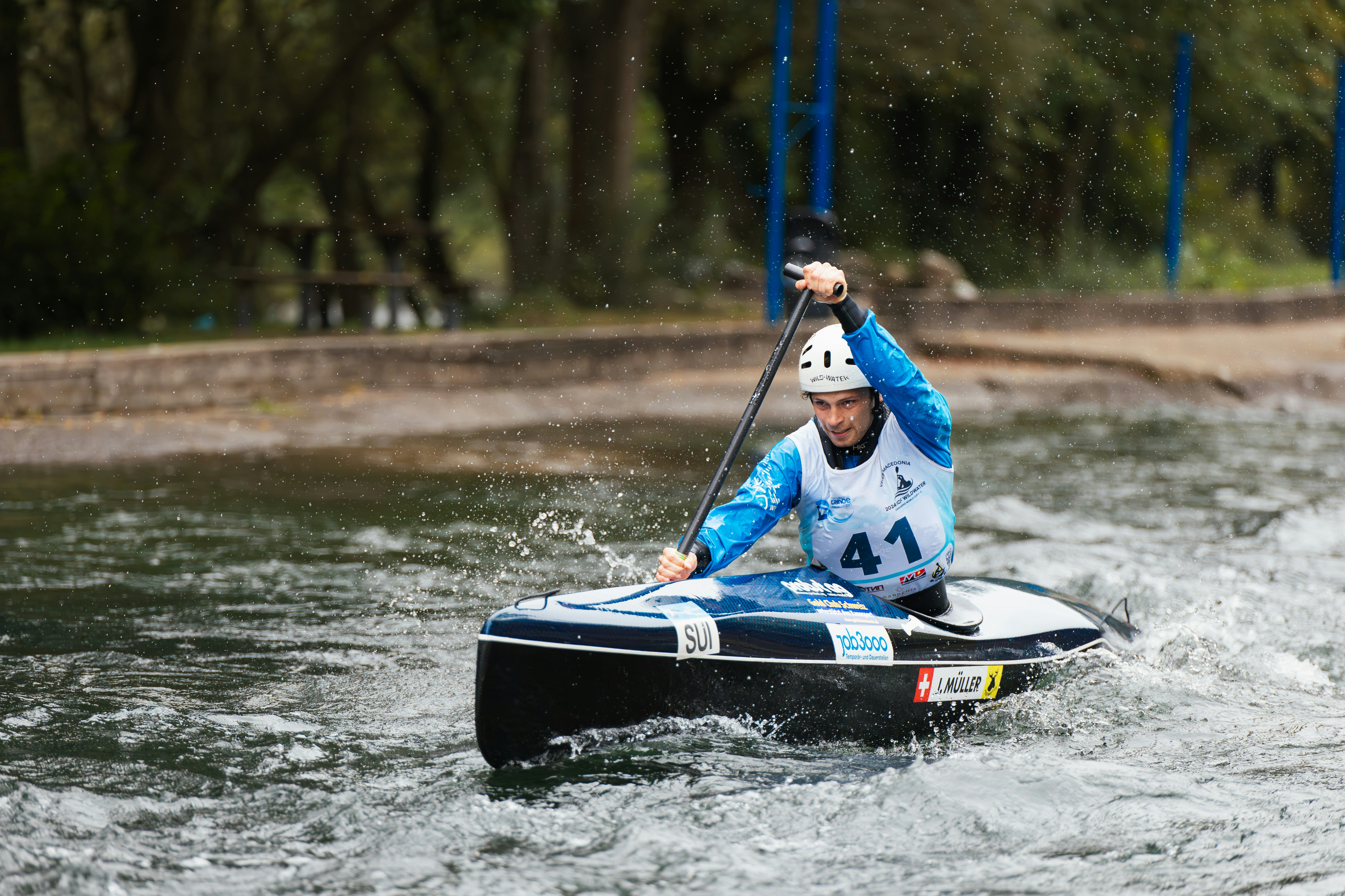 Man paddling a canoe through choppy water