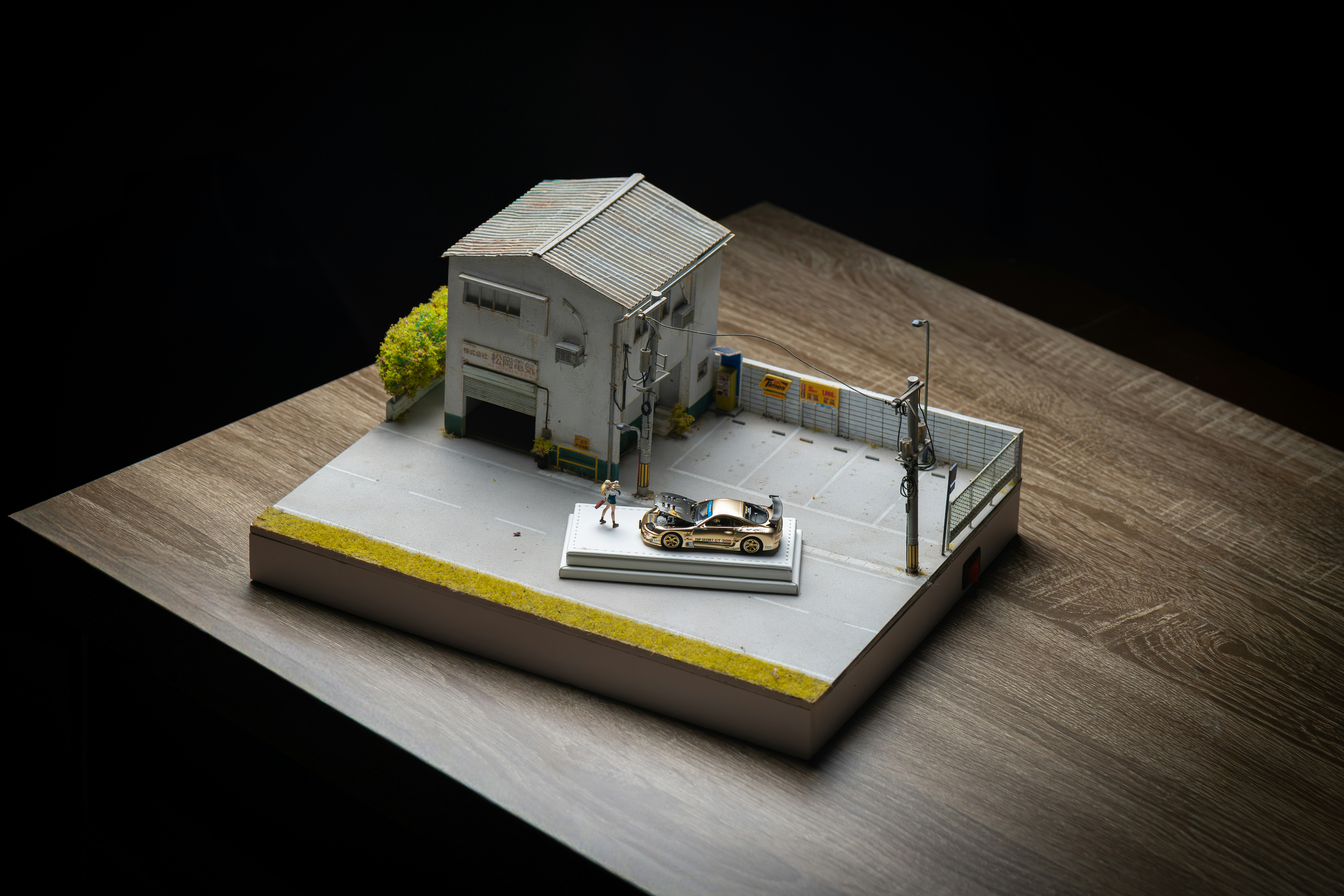 Diorama in miniatura di un edificio con un'auto.