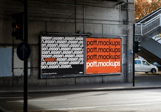 Two billboards displayed on a concrete wall