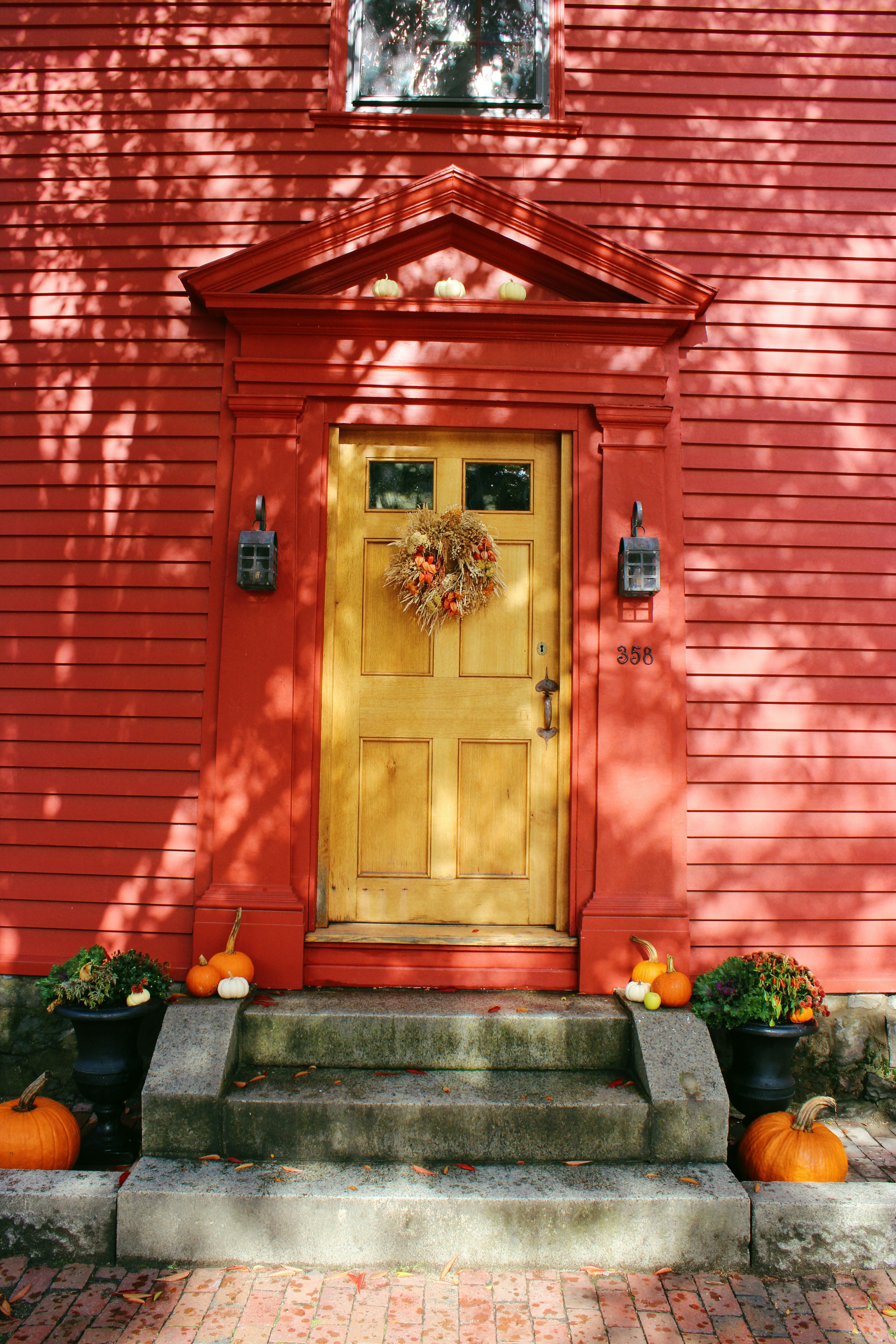 Red house with yellow door and autumn decorations