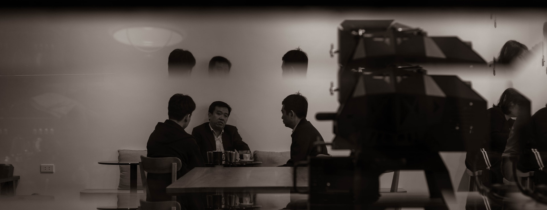 Three men sitting at a table in a restaurant.