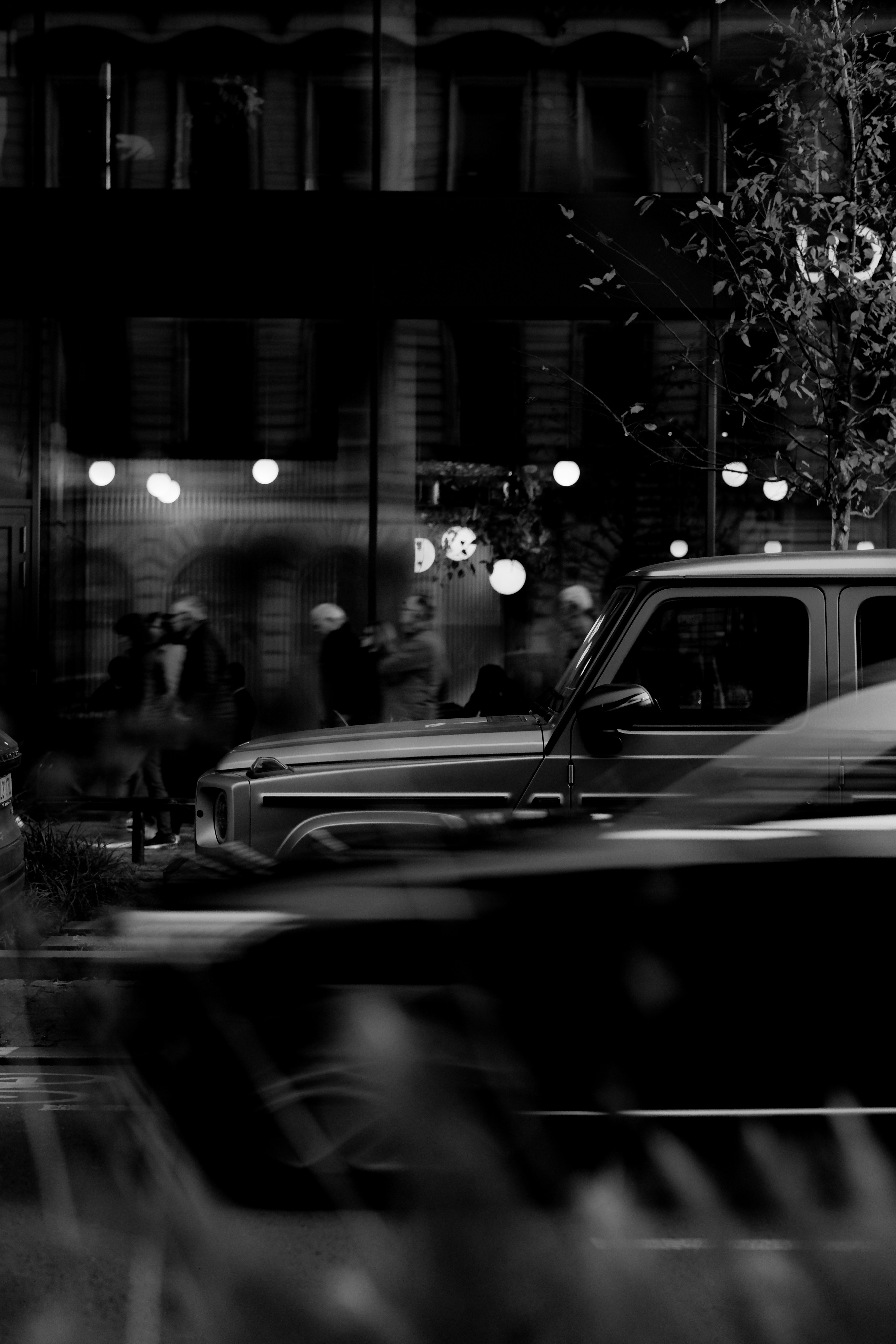 Cars blurred by motion on a city street at night.