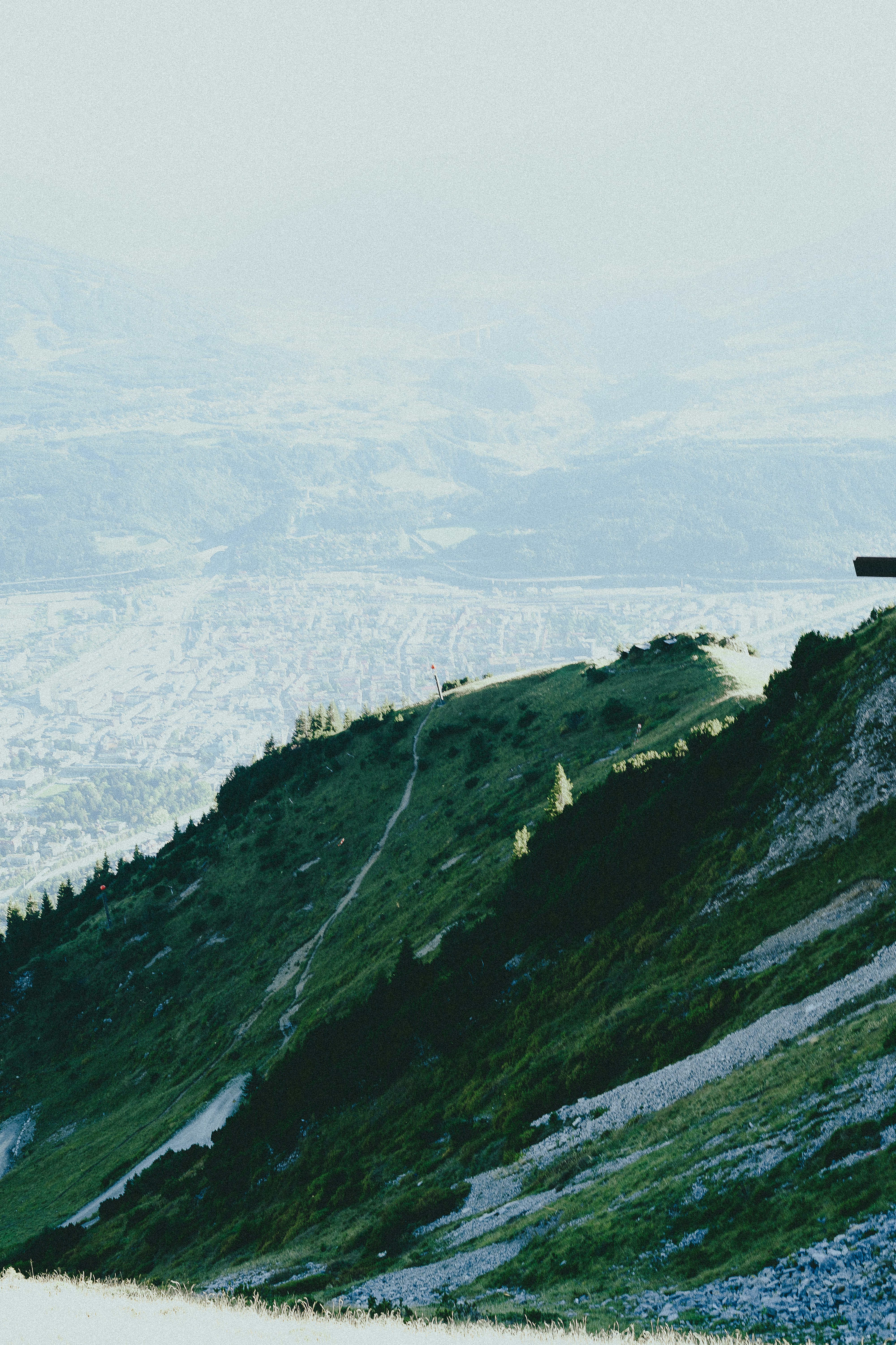 Green mountain slope with distant hazy landscape