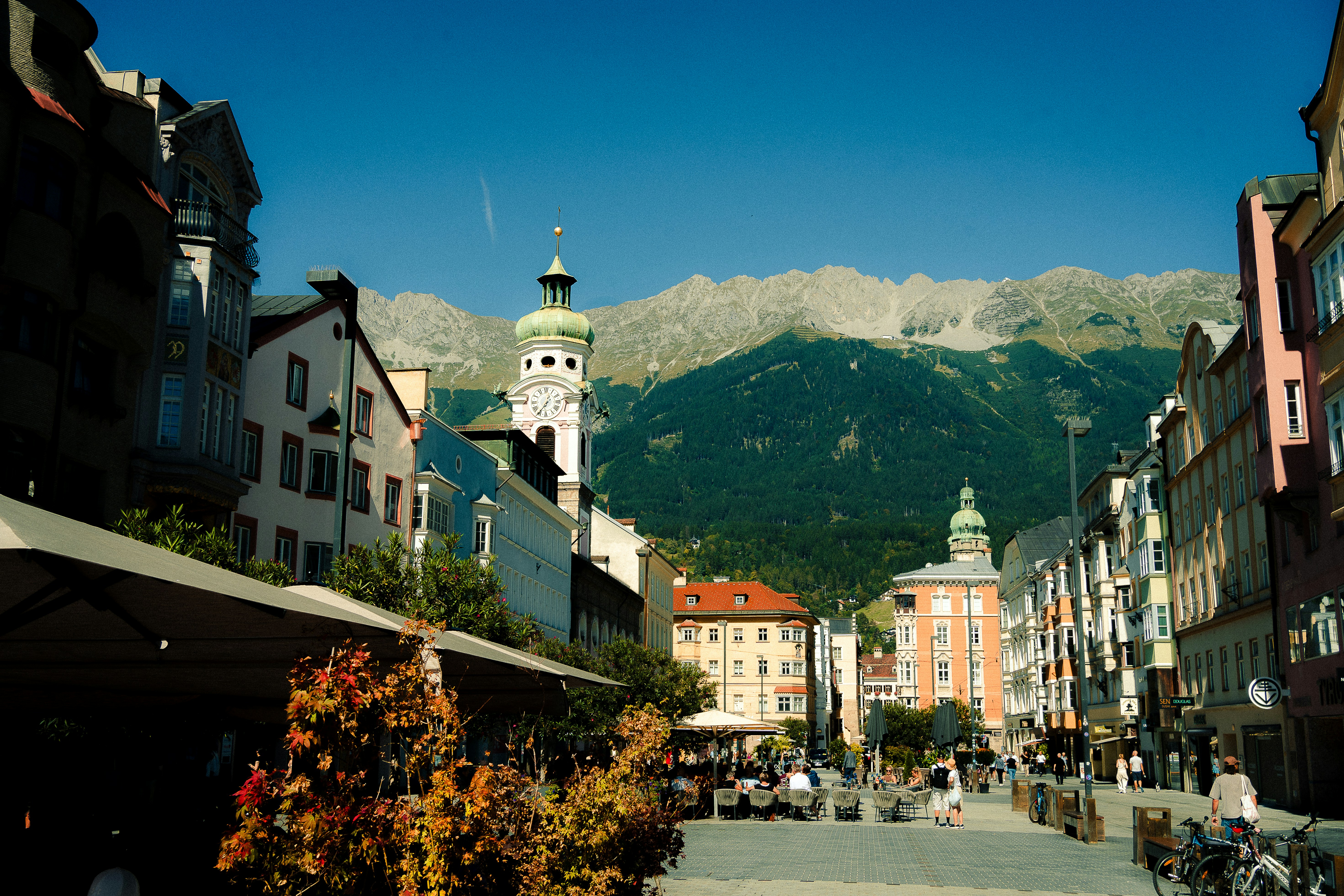 Historic european city street with mountains in background.