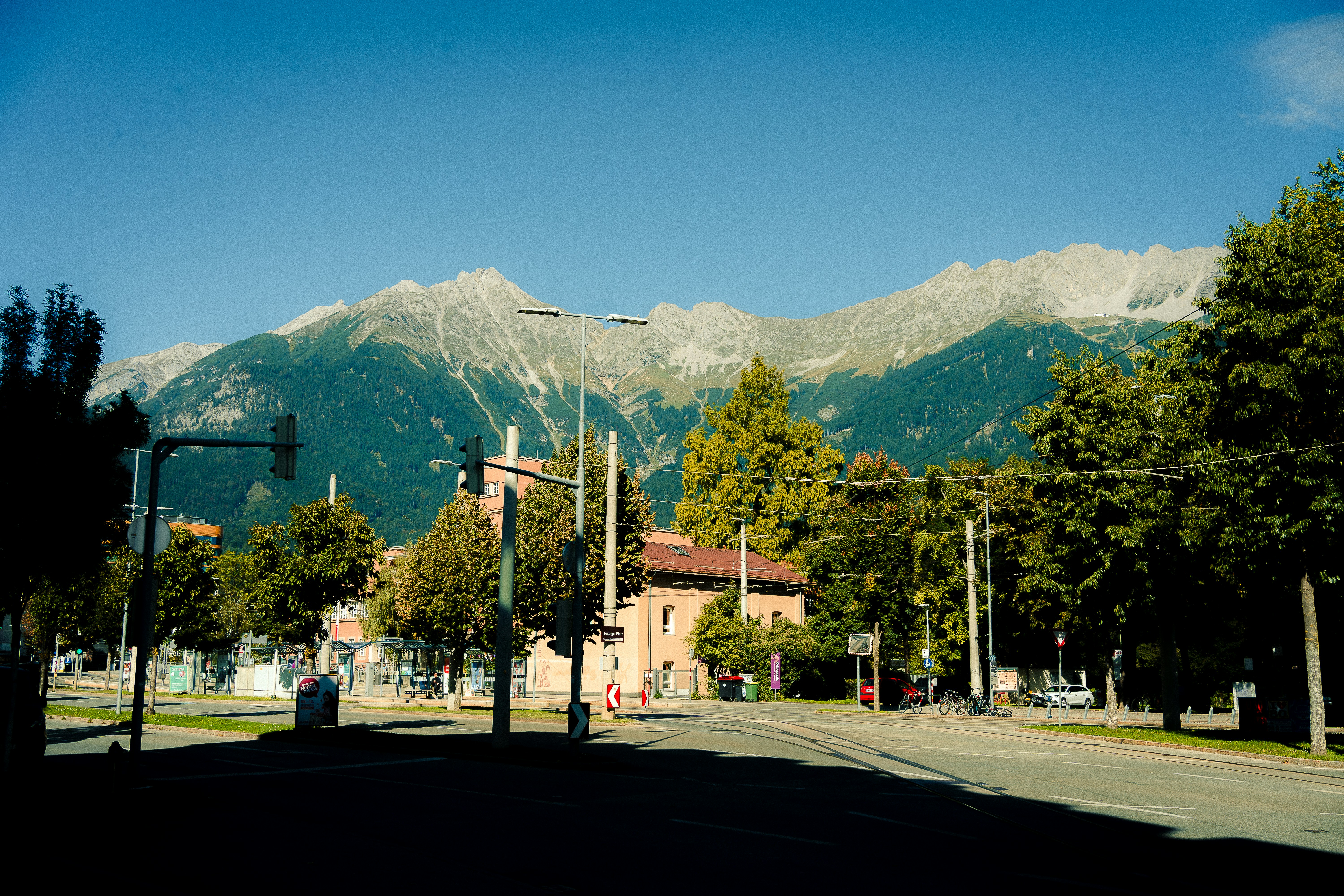 Majestic mountains rise behind a town on a sunny day.
