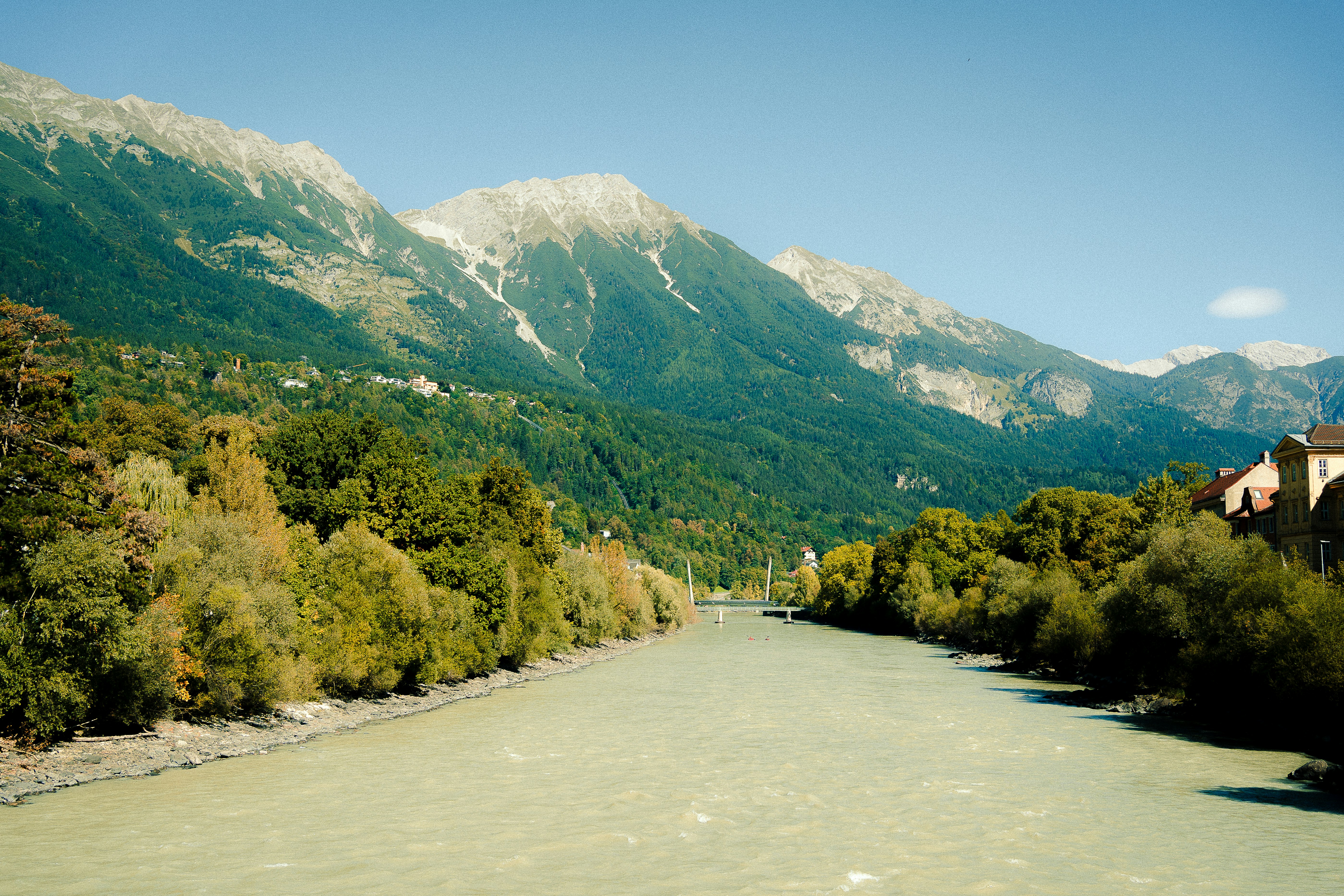 Wide river flows through a valley with mountains.