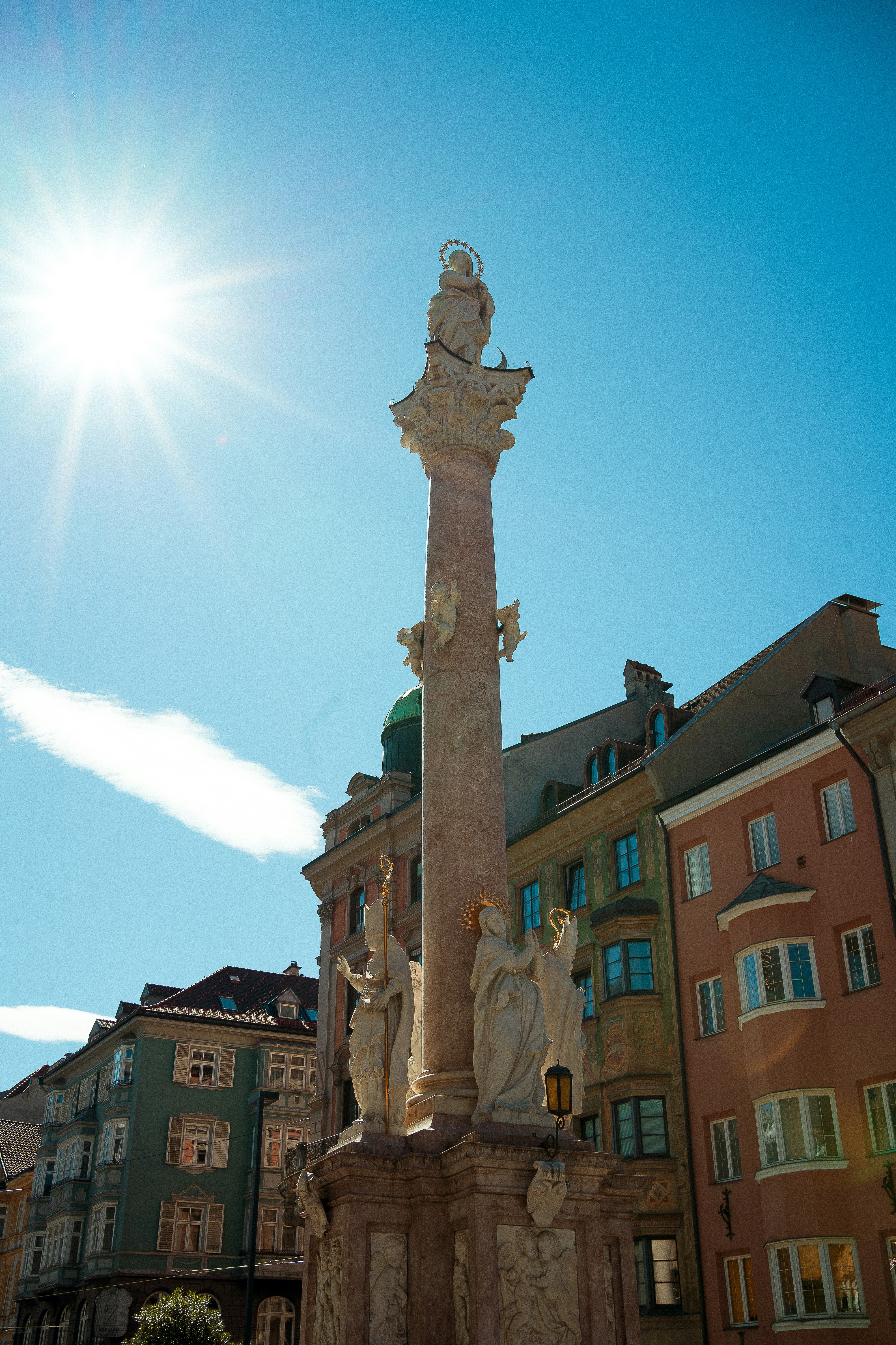 Monument with statues against colorful buildings and sky