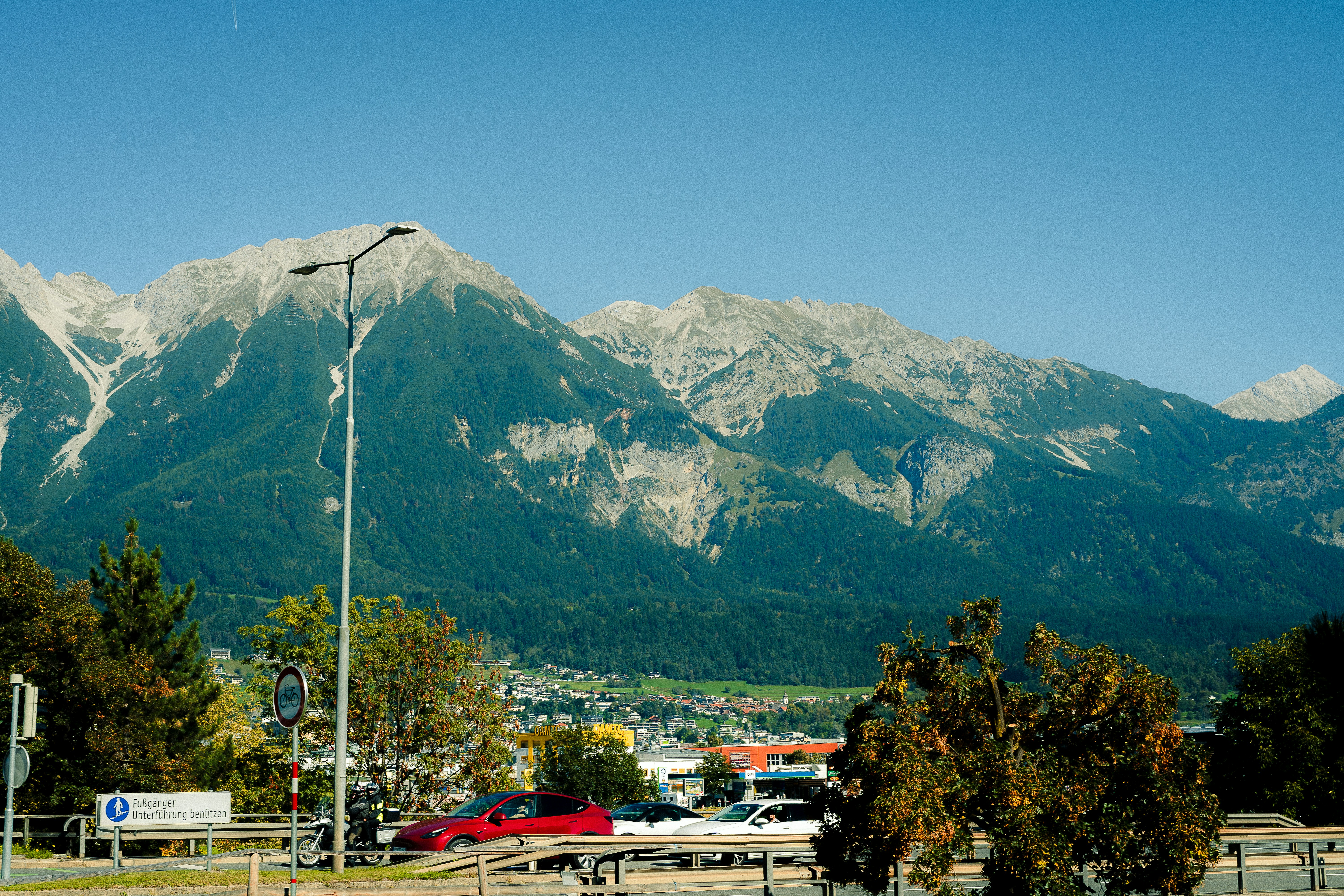 Majestic mountains rise above a town and trees.