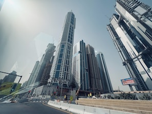 Modern skyscrapers rise against a clear blue sky.