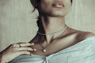 Woman wearing pearl necklaces and striped shirt