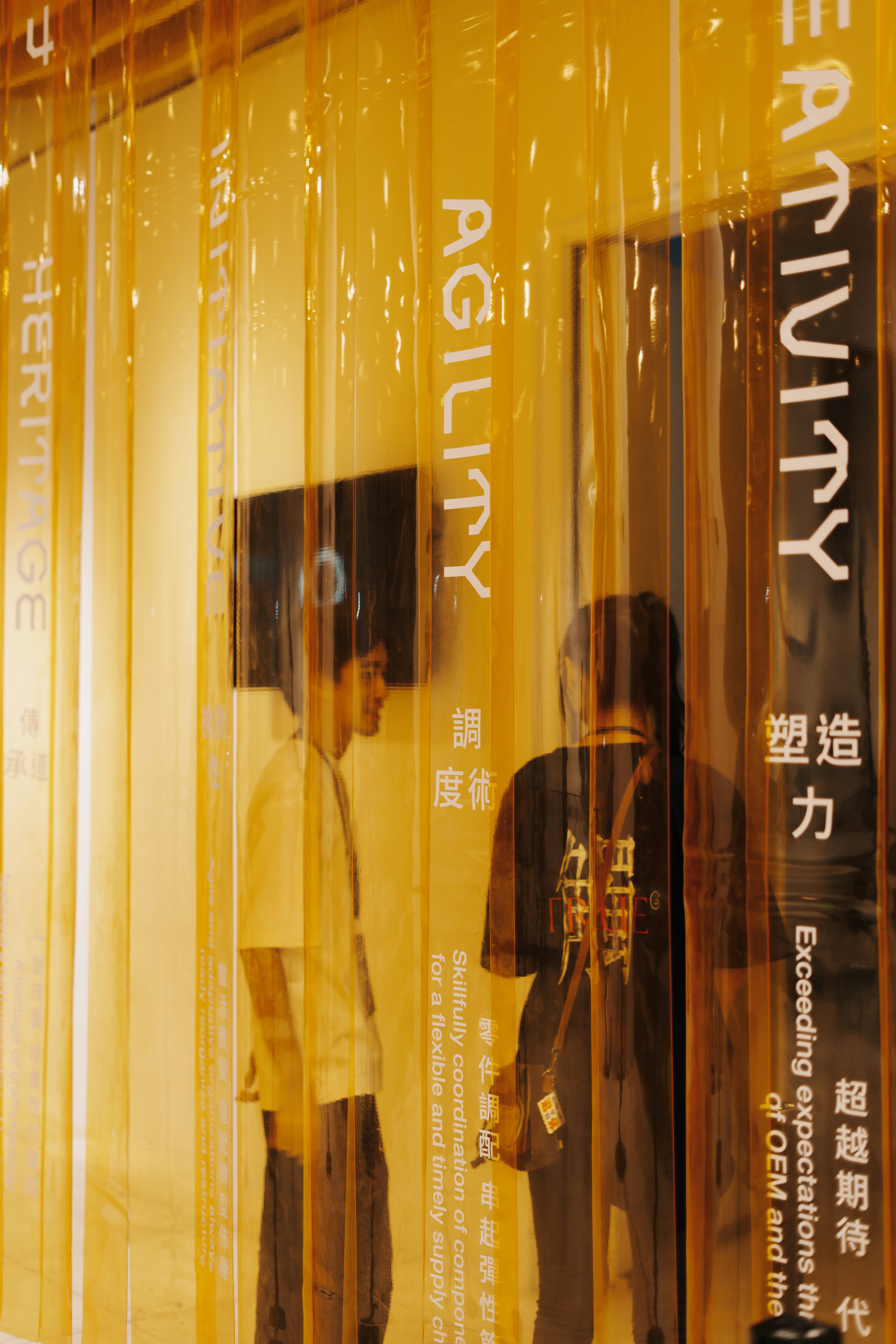 People behind yellow plastic strips with text