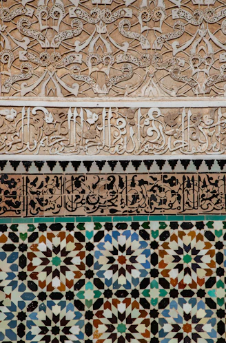 Intricate geometric tile and stucco patterns on a wall.