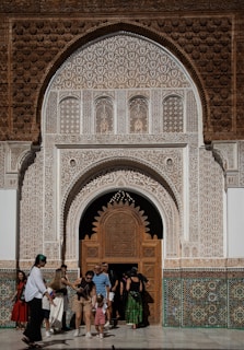 People entering ornate moroccan architectural entrance