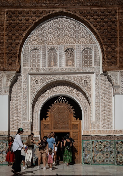 People entering ornate moroccan architectural entrance